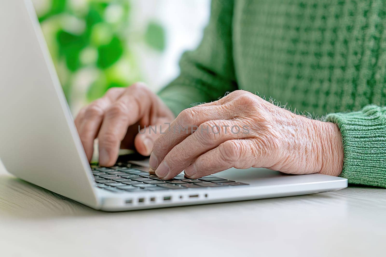 A Close up of elderly man hands carefully typing on laptop, showcasing focus and concentration