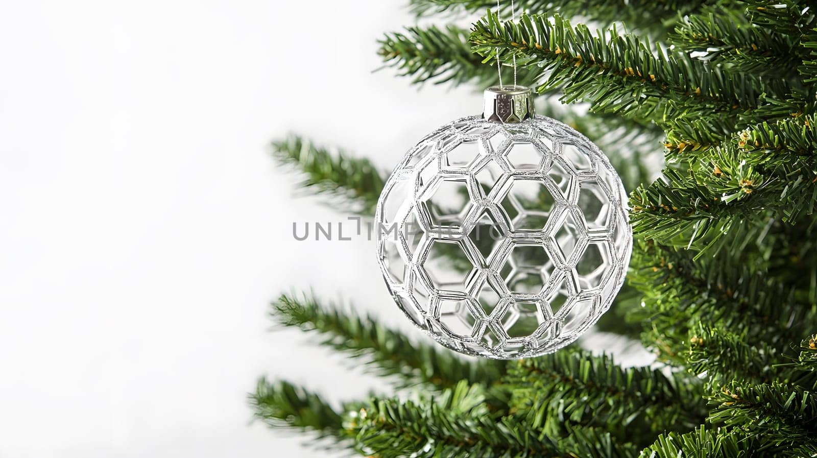 A decorative glass ornament hanging from a Christmas tree branch.
