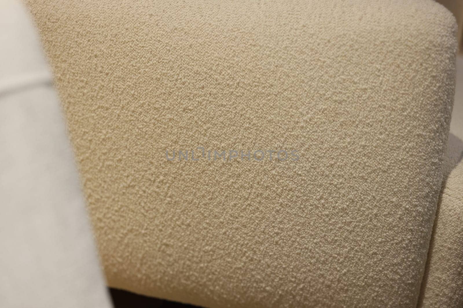 Here is a detailed view showcasing a soft, textured upholstery fabric that comes in a warm shade of beige