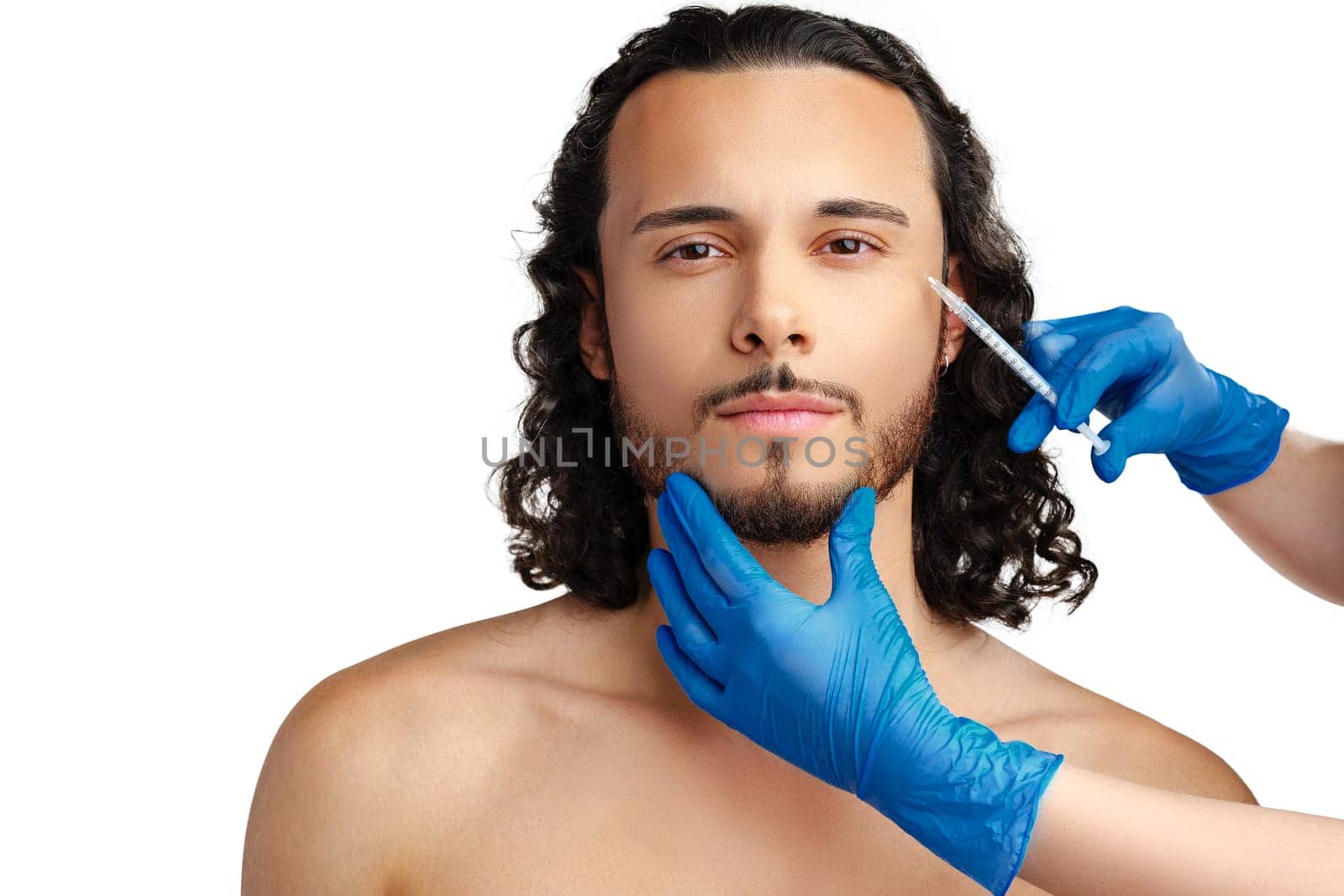 Man receiving cosmetic treatment with a syringe, showcasing a beauty procedure in a clinical setting