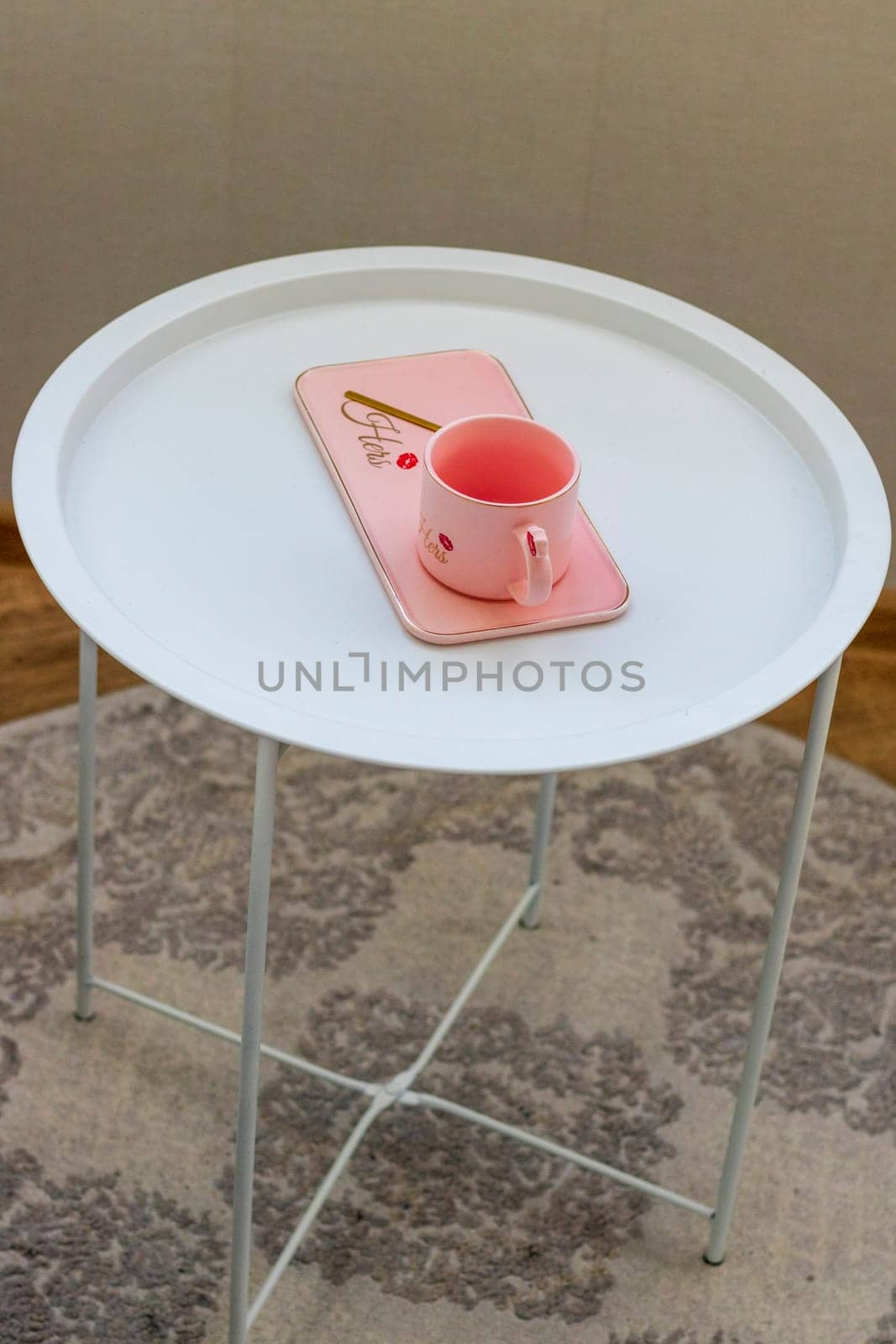 Coffee table with the pink cup for ladies on it.