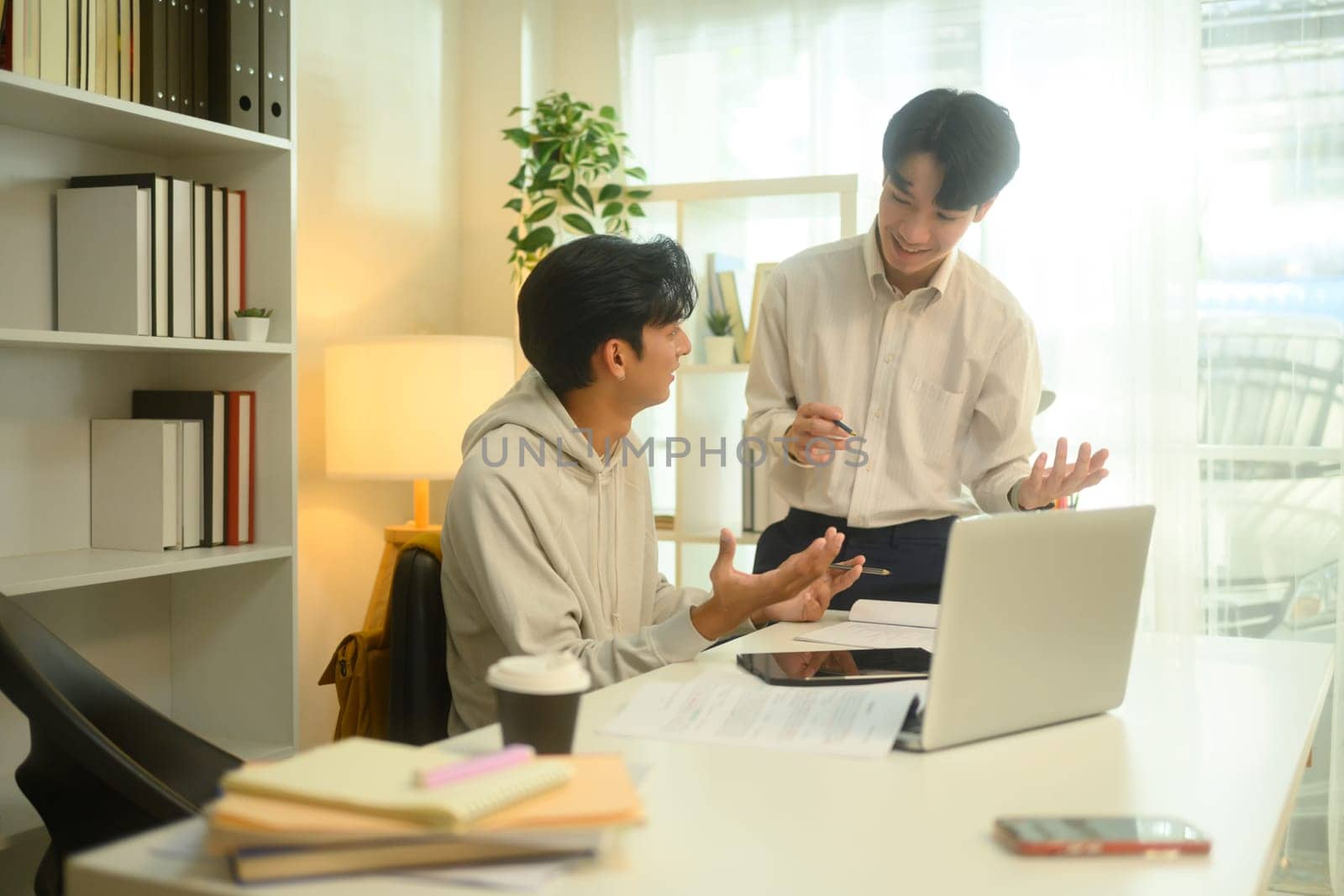 Smiling tutor guides a student through a lesson during a home tutoring session.