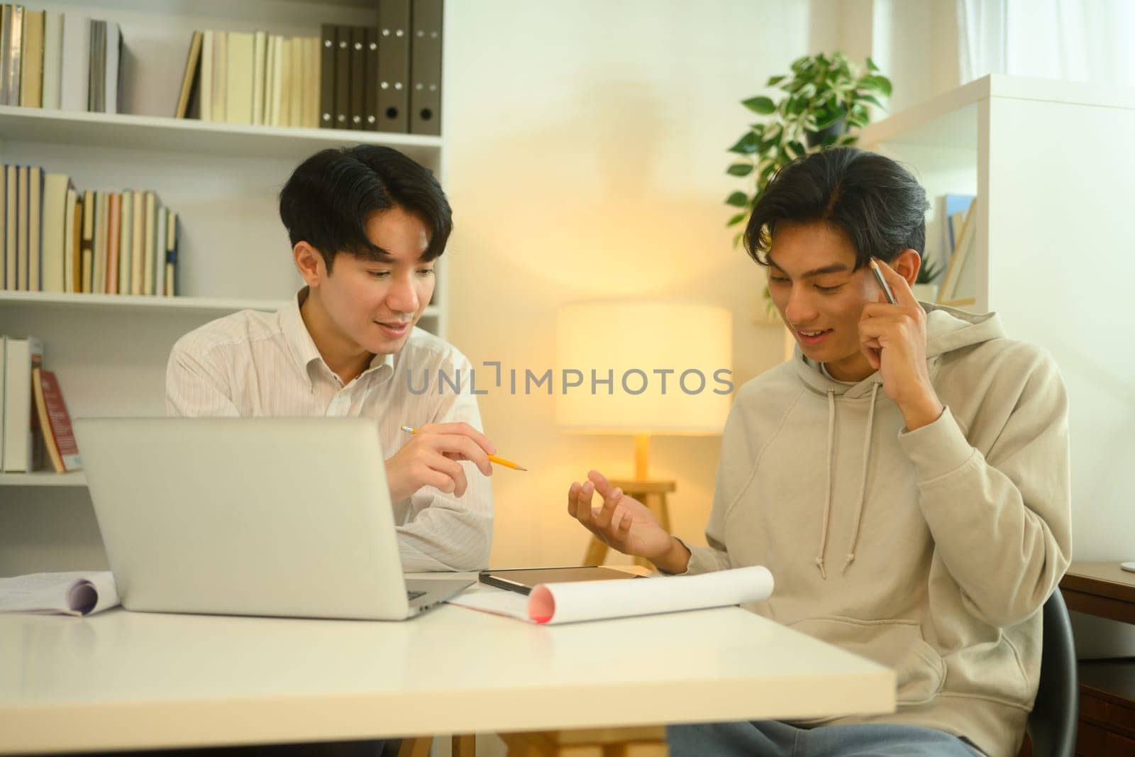 Tutor and student sharing ideas and discussing study materials during a home tutoring session.