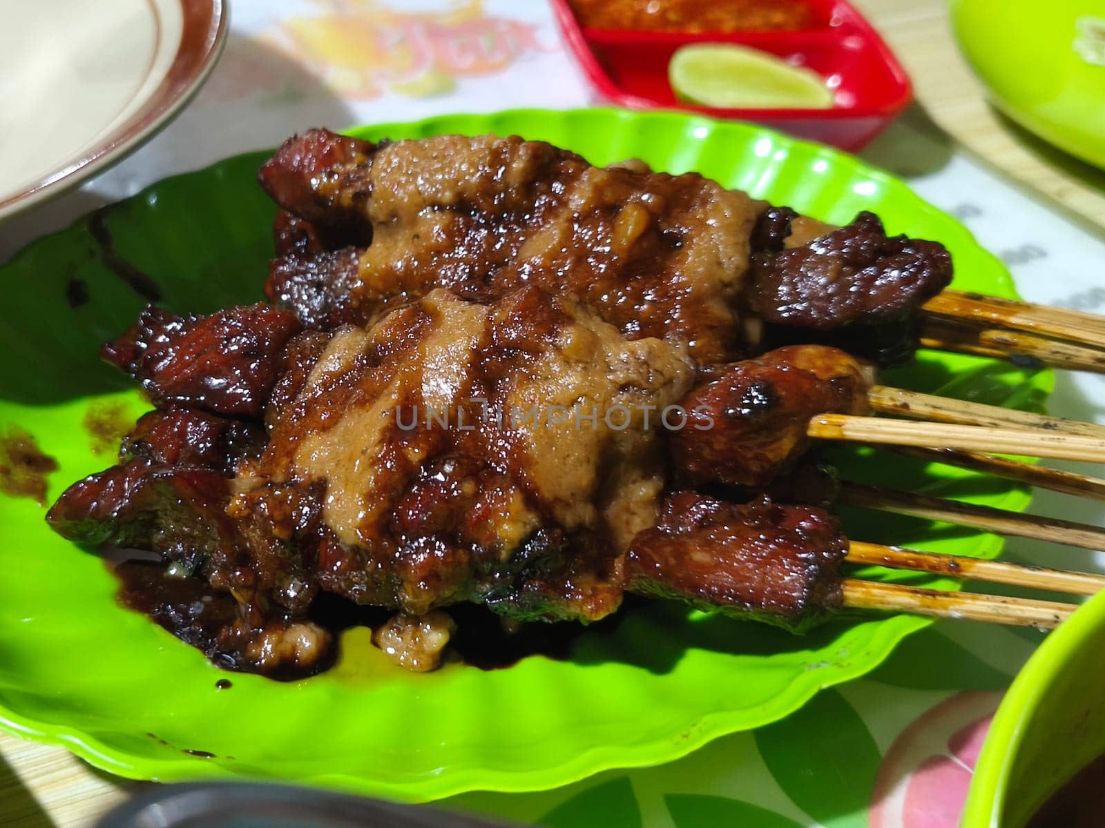 A plate of succulent-looking Sate Kambing or goat satay with peanut sauce, ready to be devoured. This is from Indonesia.