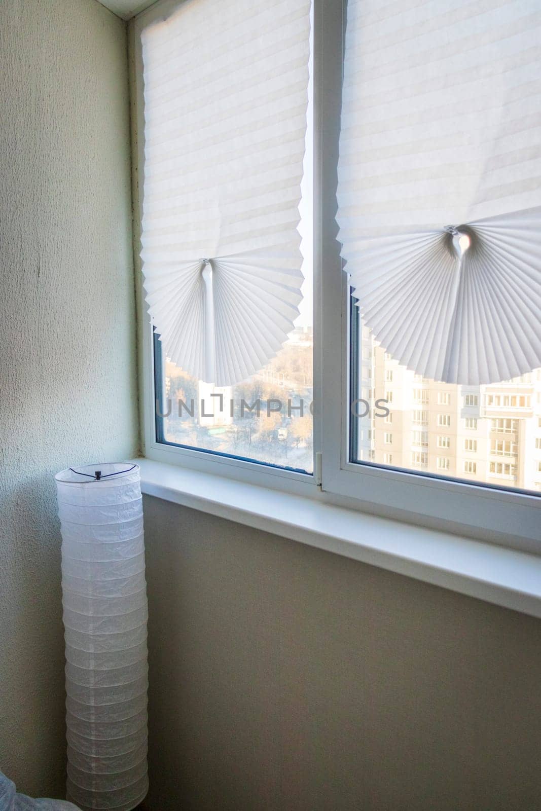 Paper blinds on the window in the balcony of the apartment