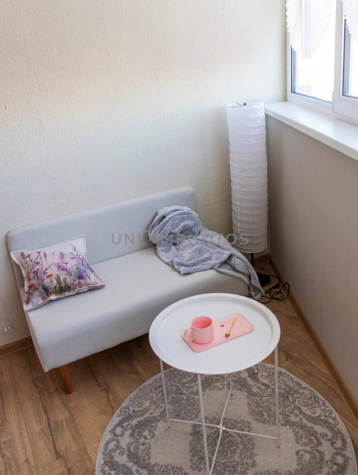 Interior of the balcony of the modern apartment. Sofa, coffee table, standing light
