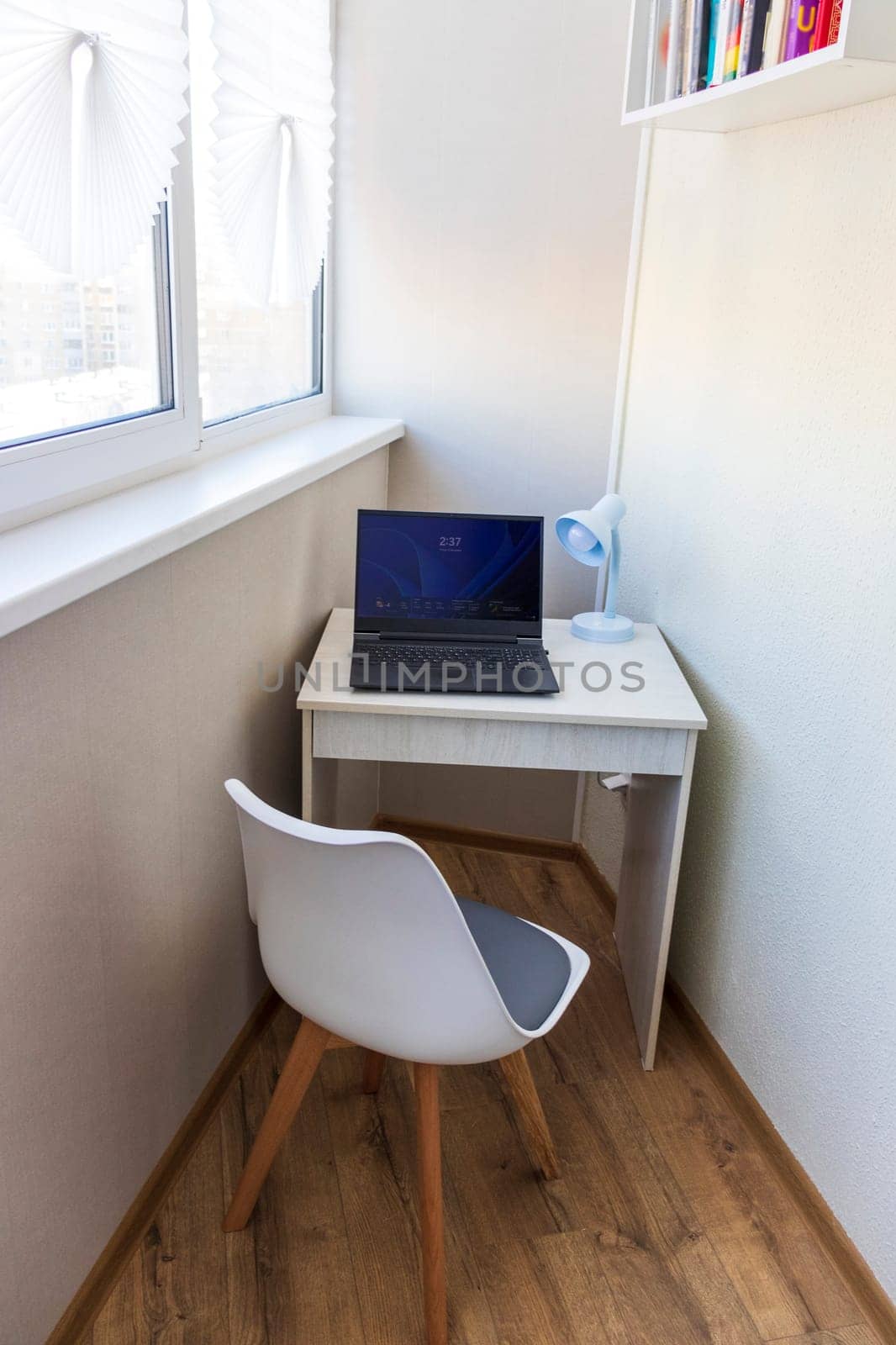 Tiny working space in the apartment. Laptop on the desk.
