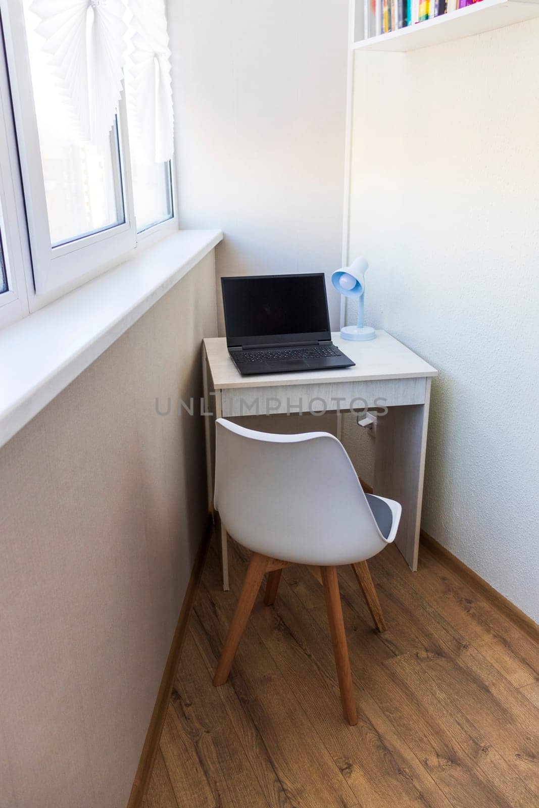 Tiny working space in the apartment. Laptop on the desk.