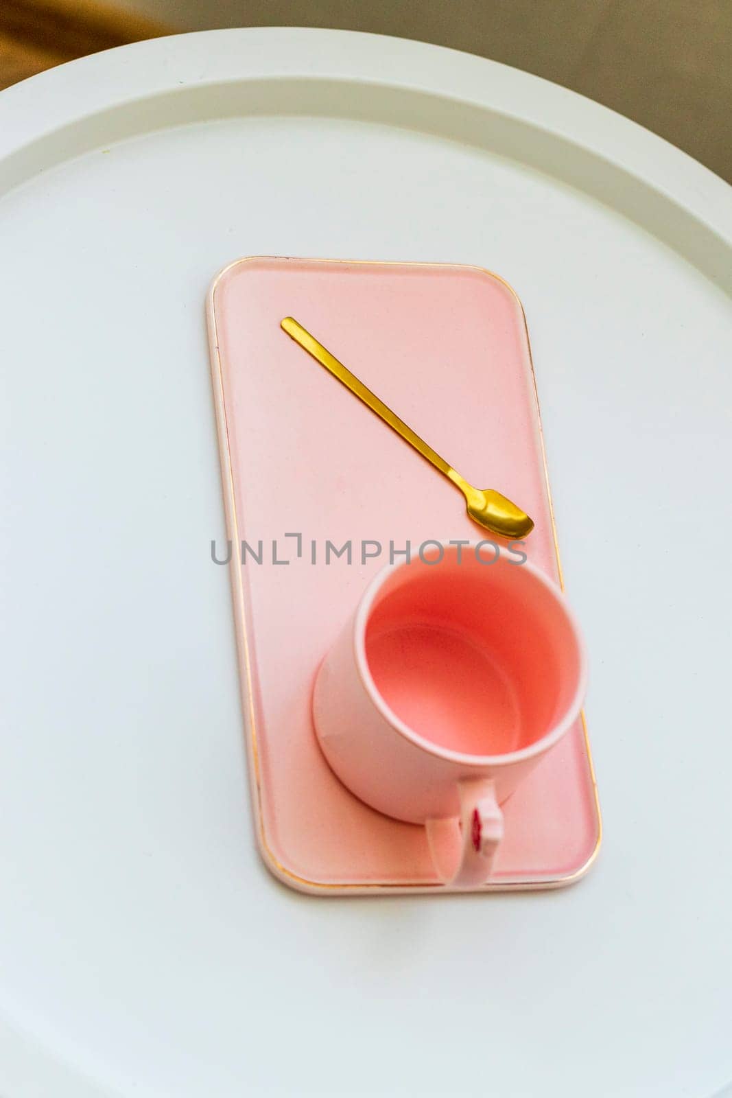 Coffee table with the pink cup for ladies on it.