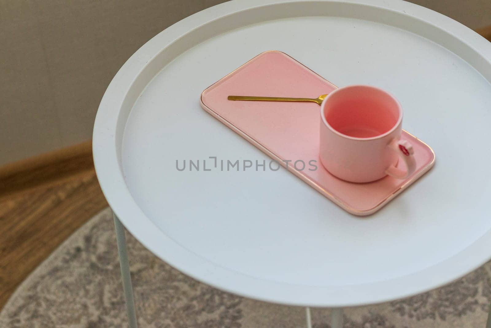 Coffee table with the pink cup for ladies on it. Concept