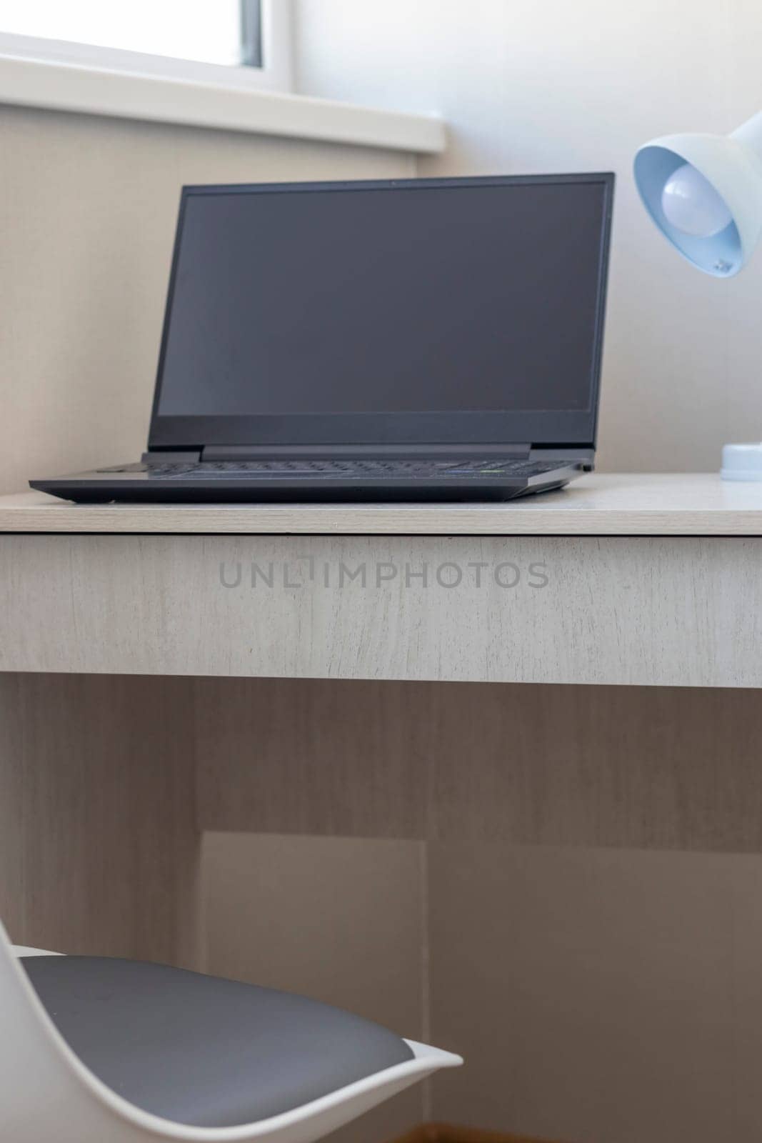 Tiny working space in the apartment. Laptop on the desk.