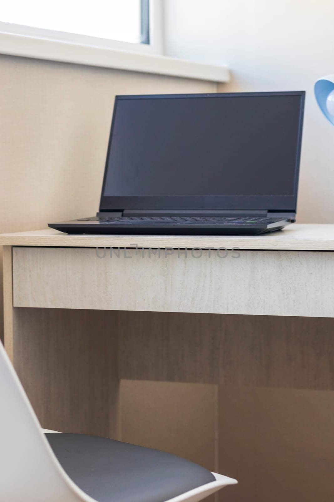 Tiny working space in the apartment. Laptop on the desk.