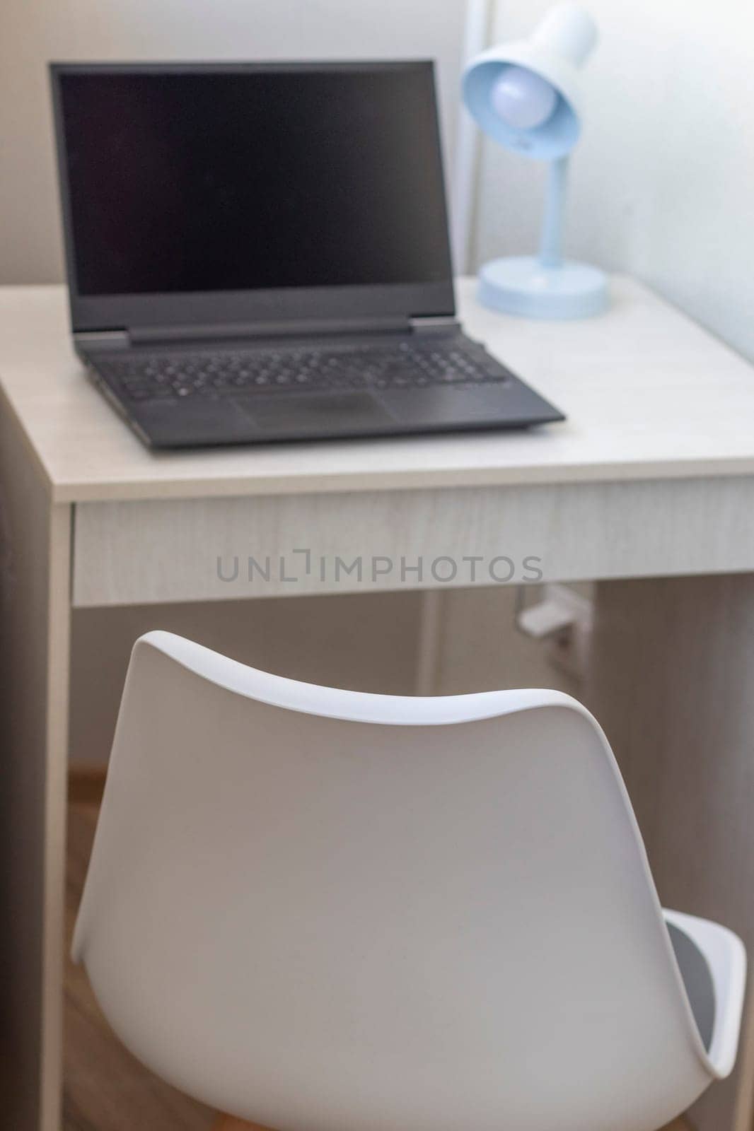 Tiny working space in the apartment. Laptop on the desk.