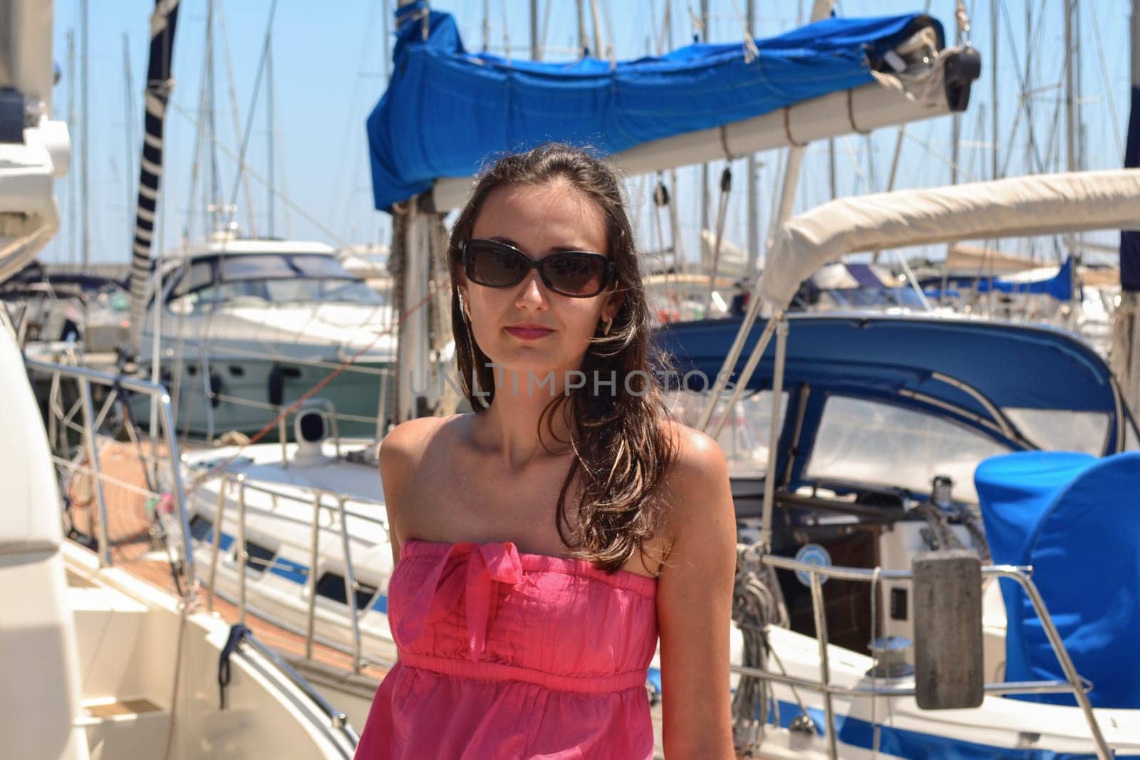 Brunette beautiful woman with glasses near yachts in Italy