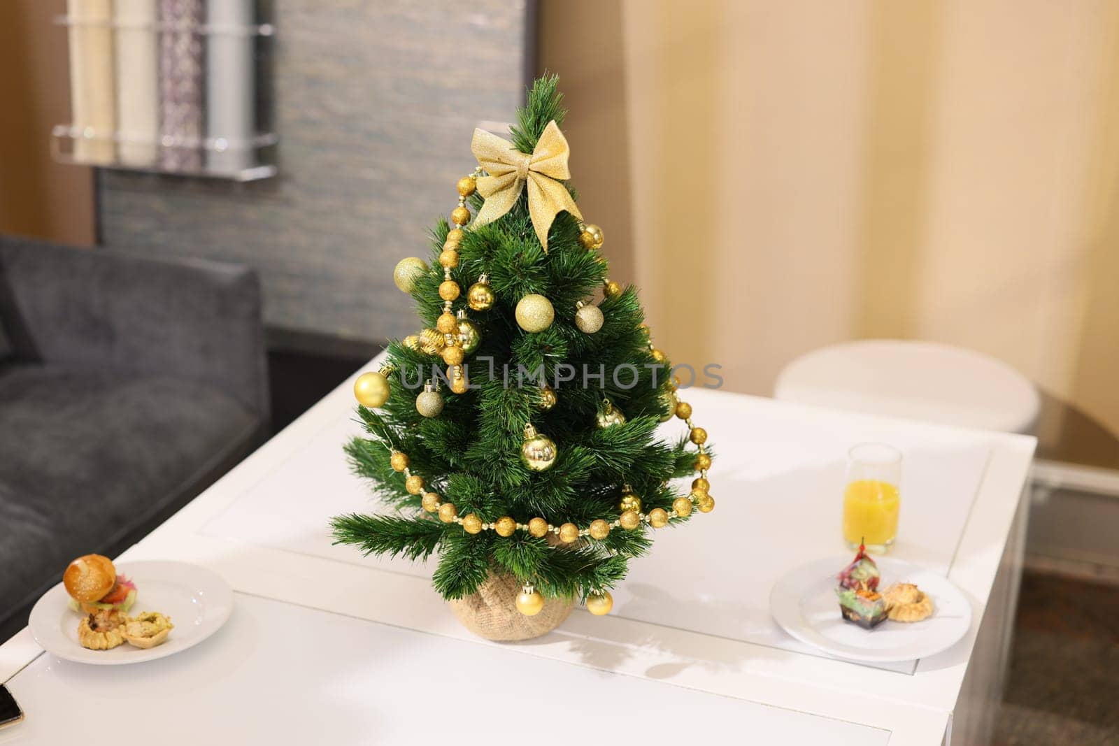 A cozy and festive Christmas table setting featuring a beautifully decorated tree, delicious snacks, and a warm drink