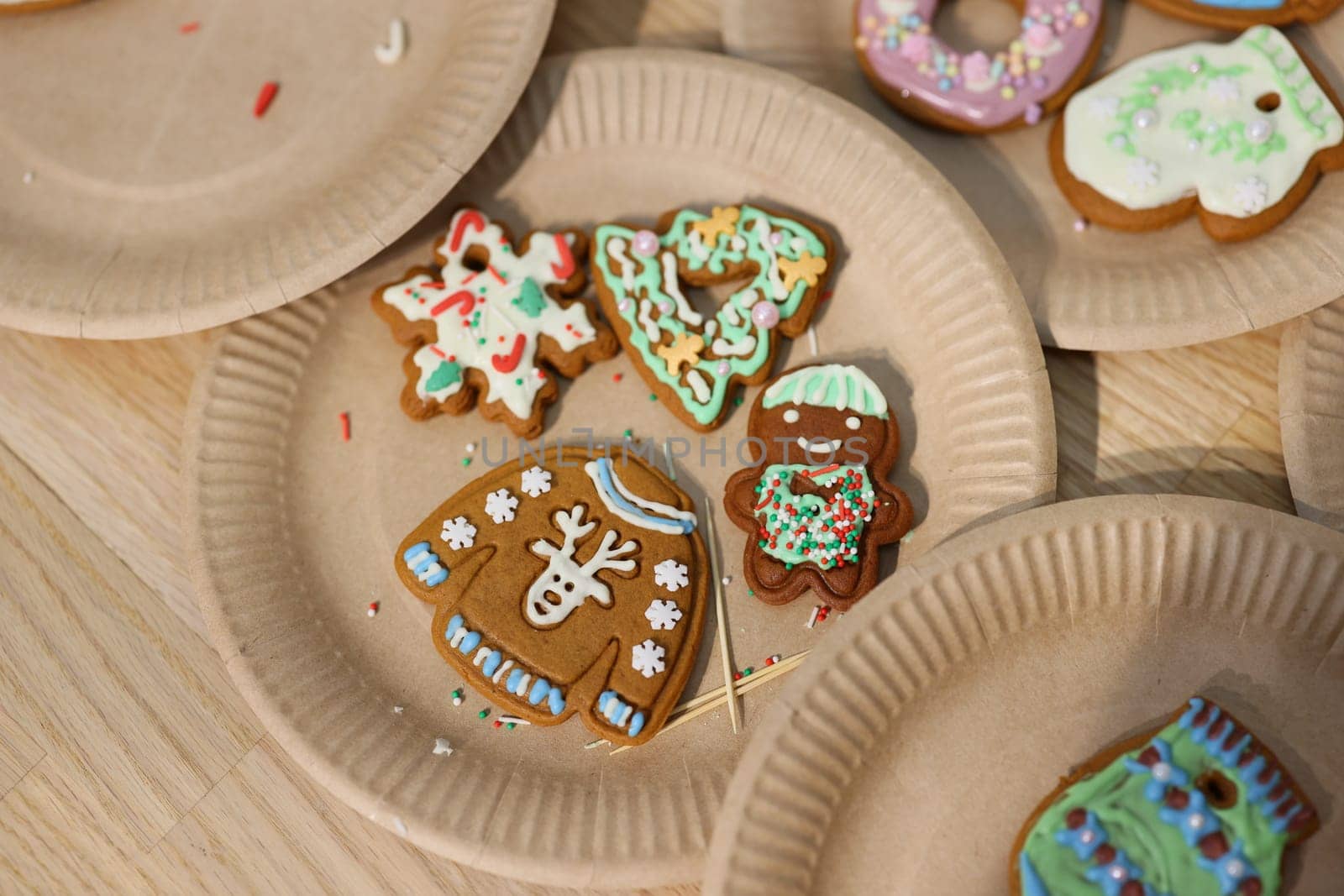 Delightful festive gingerbread cookies adorned with colorful icing and charming decorations on paper plates