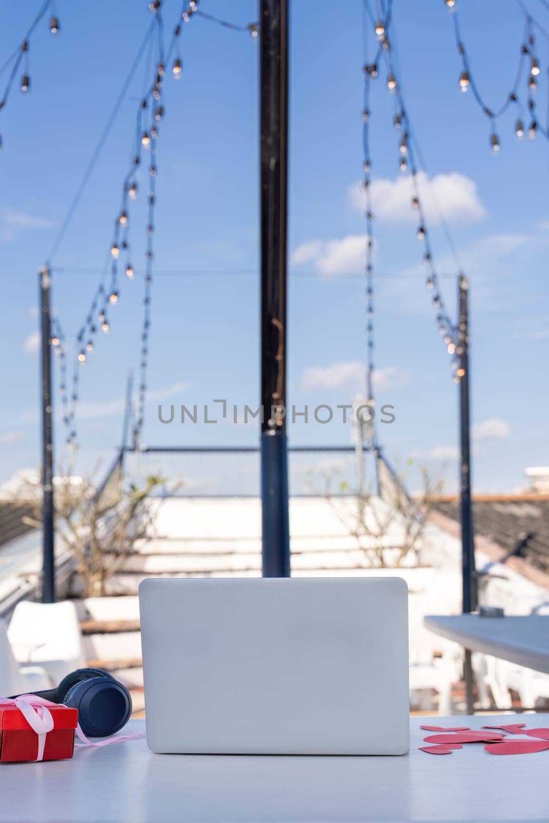 A serene rooftop workspace featuring a laptop and decor perfect for creative productivity on a sunny day.