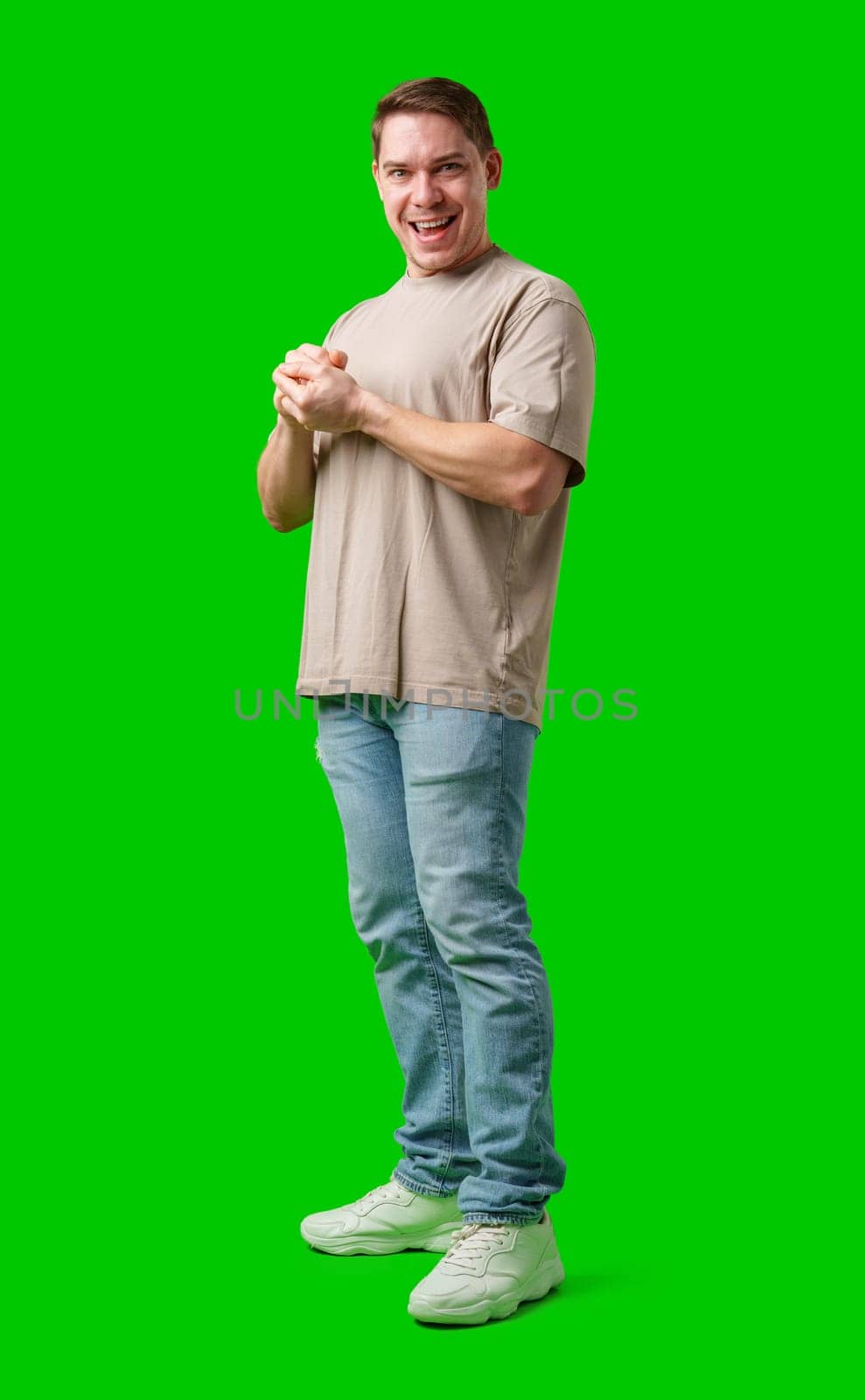 A cheerful man with a friendly smile poses against a bright green background in studio