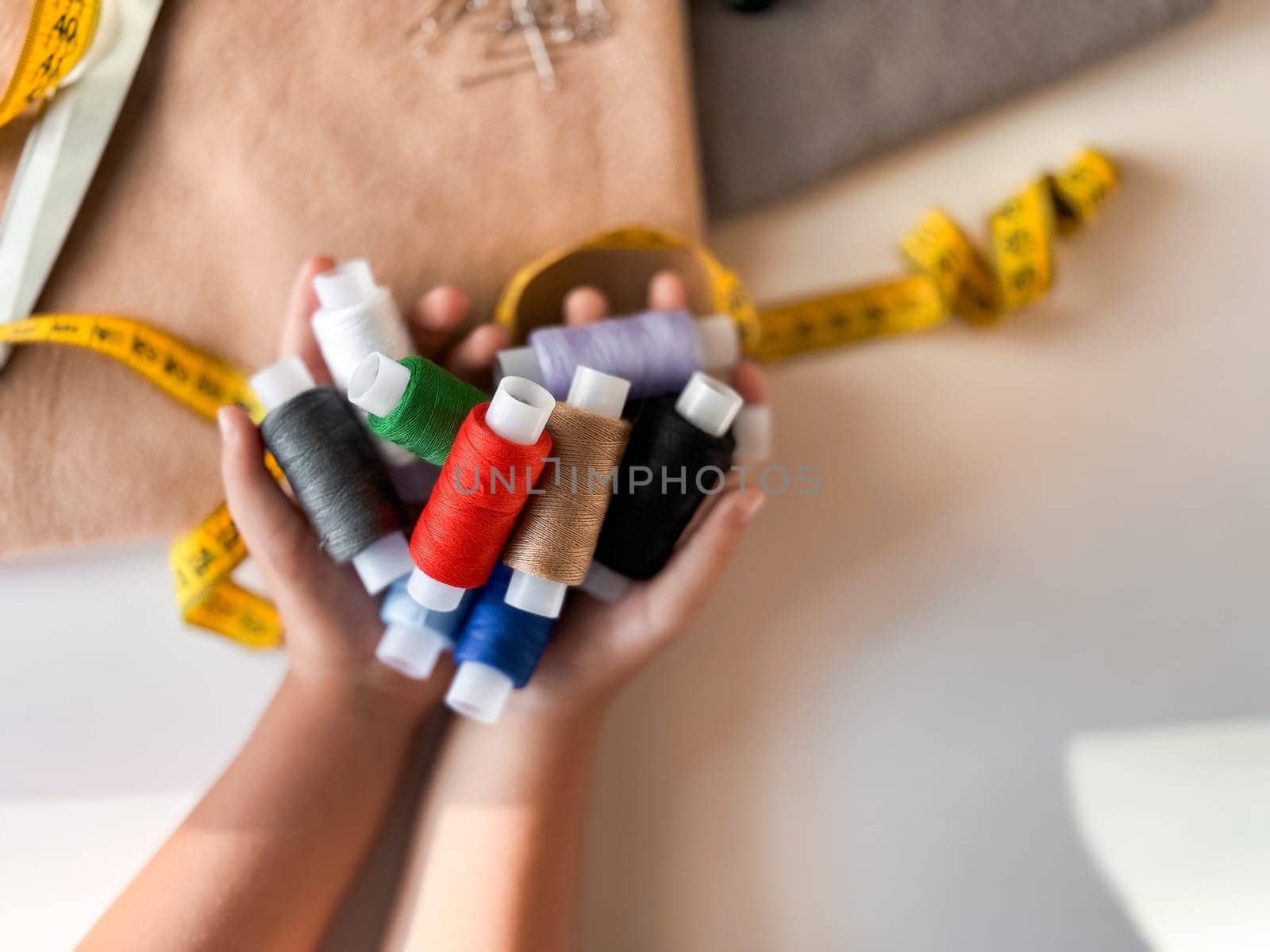 Colorful threads and measuring tape in crafting hands.