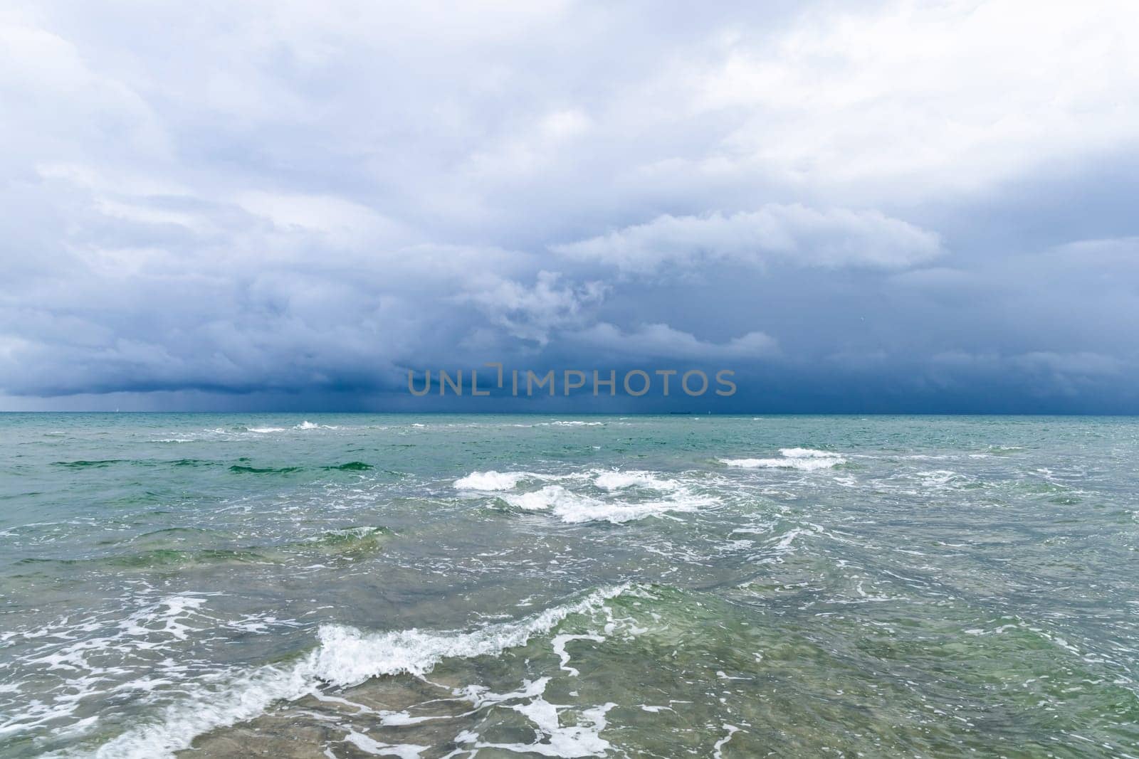 Dramatic seascape in dark colors. Dark sky with clouds over the stormy sea. High quality photo