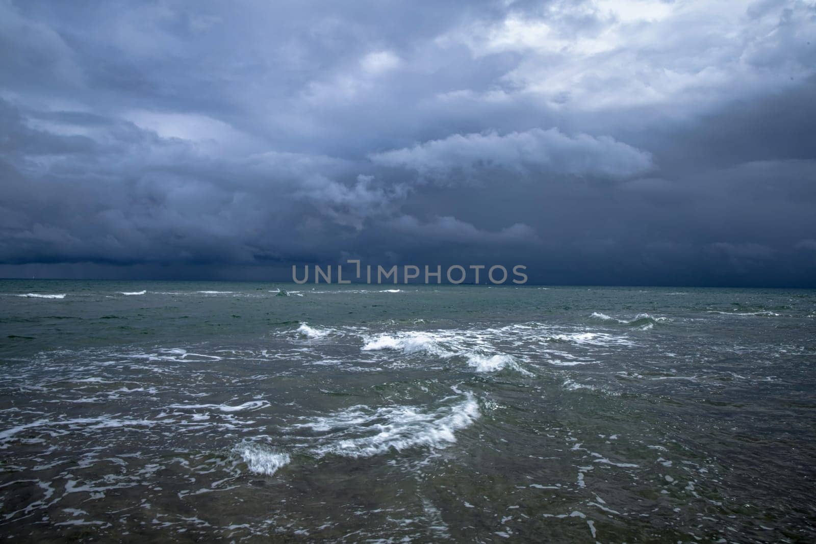 Dramatic seascape in dark colors. Dark sky with clouds over the stormy sea. High quality photo