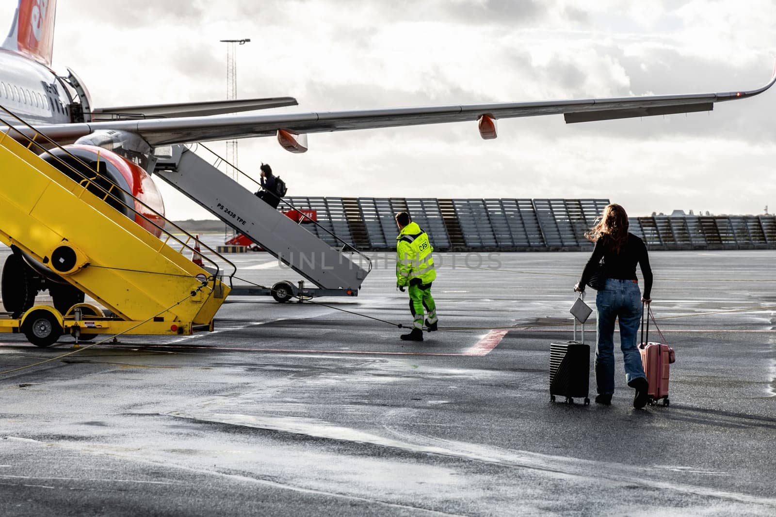 Easy Jet plane parked at Copenhagen airport. People boarding to the airplane. Copenhagen, Denmark - November 27, 2024