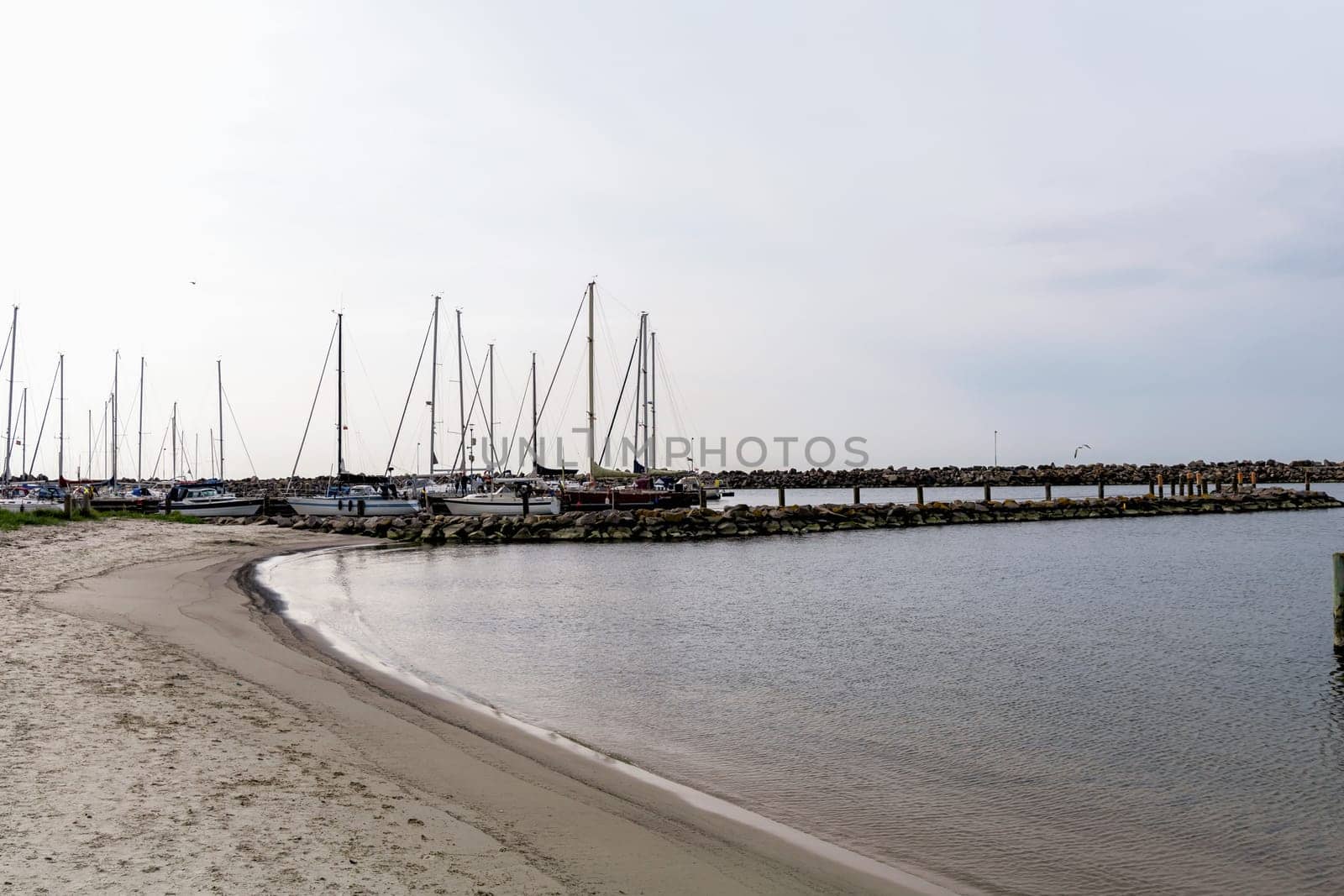 Sea pier with boats and yachts at sunset. Bornholm, Denmark - November 20, 2024. High quality photo