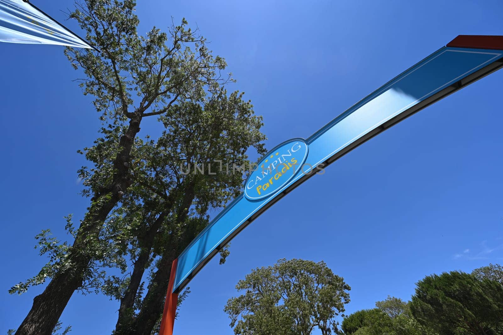 Camping Paradis sign, four stars against a blue sky in Port Grimaud. High quality photo
