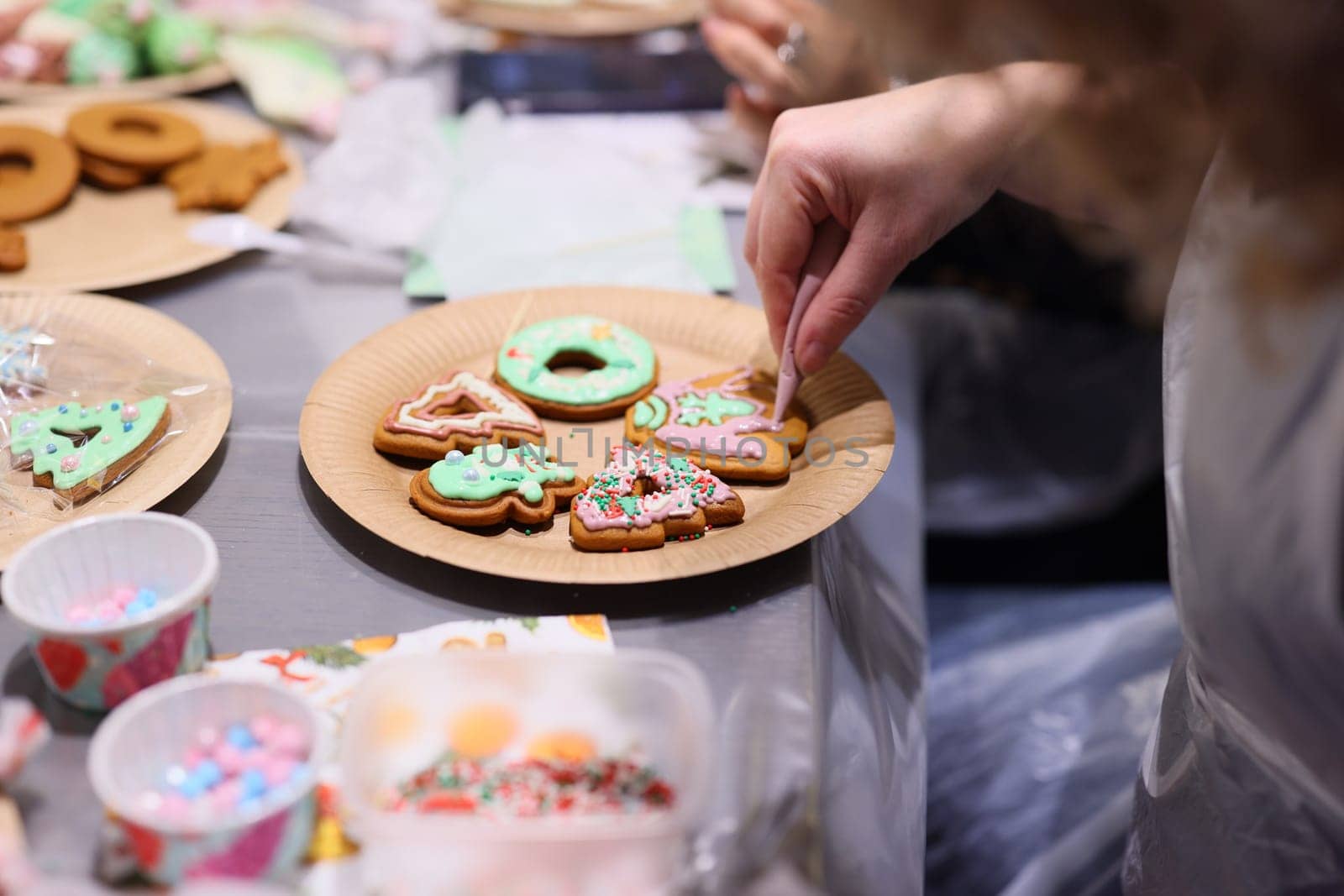 A festive scene of cookie decorating with colorful icing and sprinkles, perfect for winter celebrations.