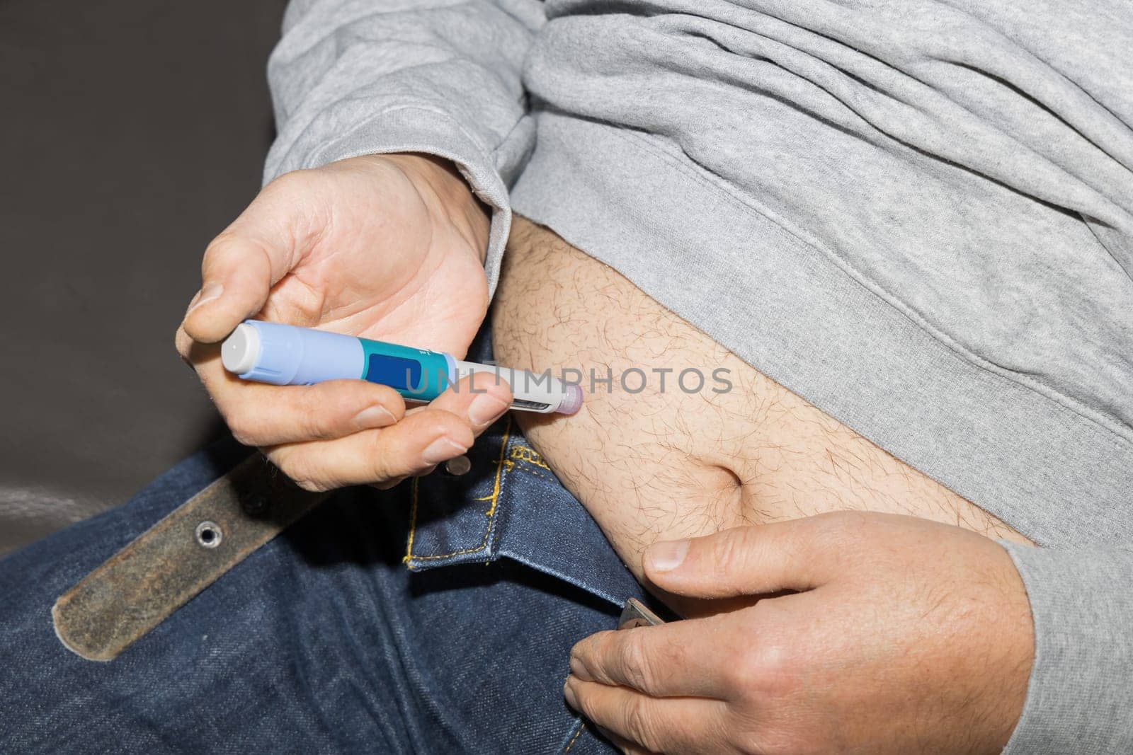 Diabetic man injects himself with Ozempic Insulin injection pen for diabetics.