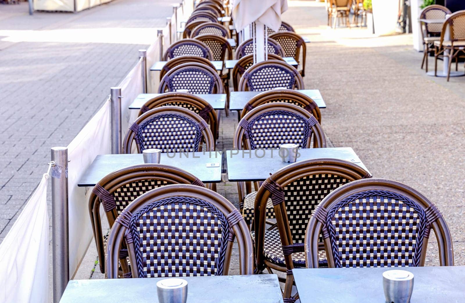 Summer restaurant on the city street. Empty restaurant summer terrace with tables and chairs. Outdoor cafe.