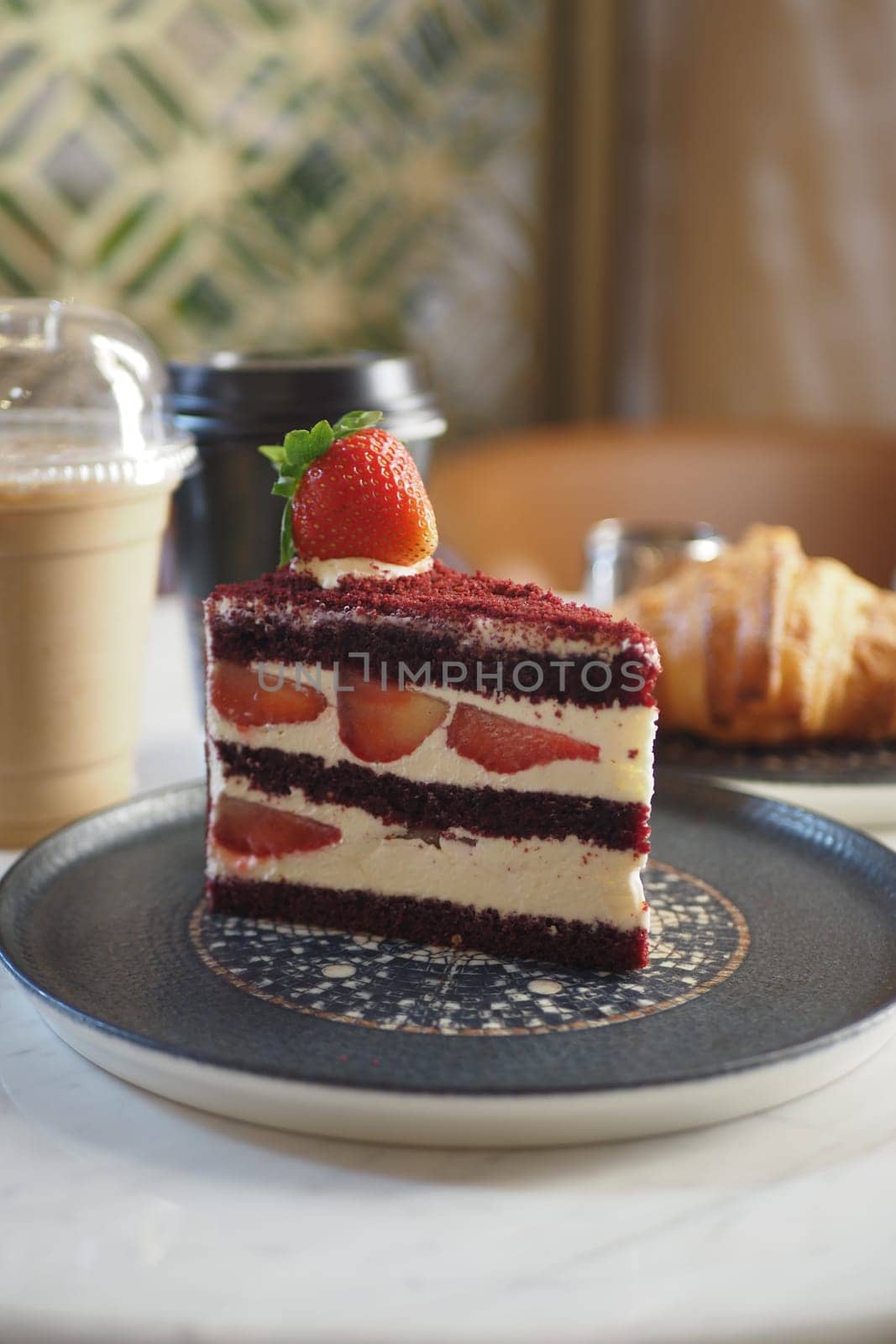 A deliciously tempting slice of indulgent red velvet cake adorned with fresh strawberries