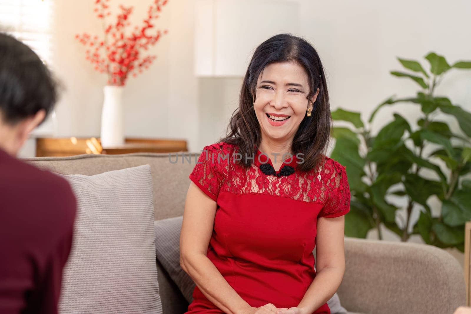 An elderly woman joyfully partakes in Chinese New Year festivities embodying rich traditions and familial warmth.