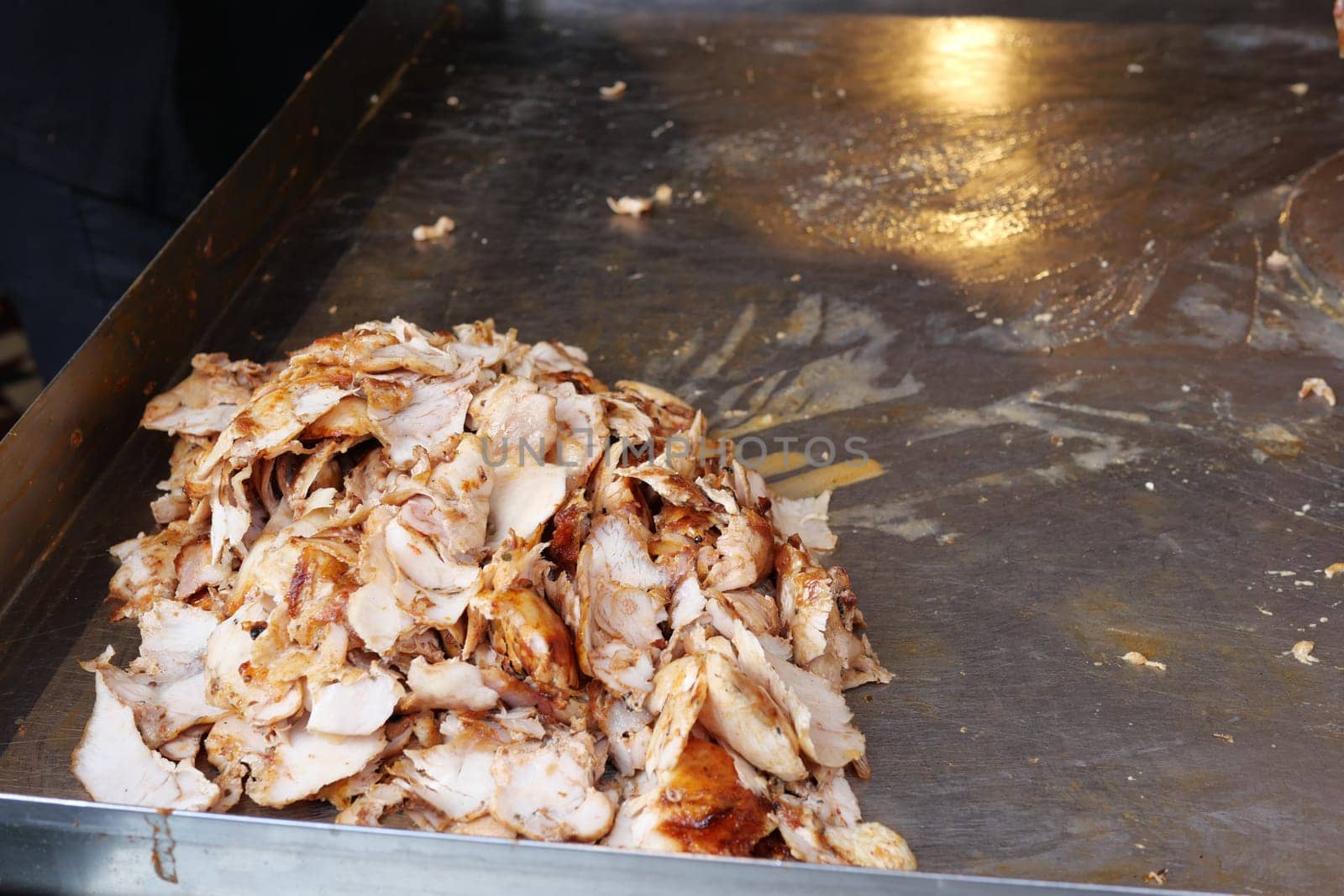 Deliciously cooked, tender shredded meat is sizzling on a hot grill surface, enticing all