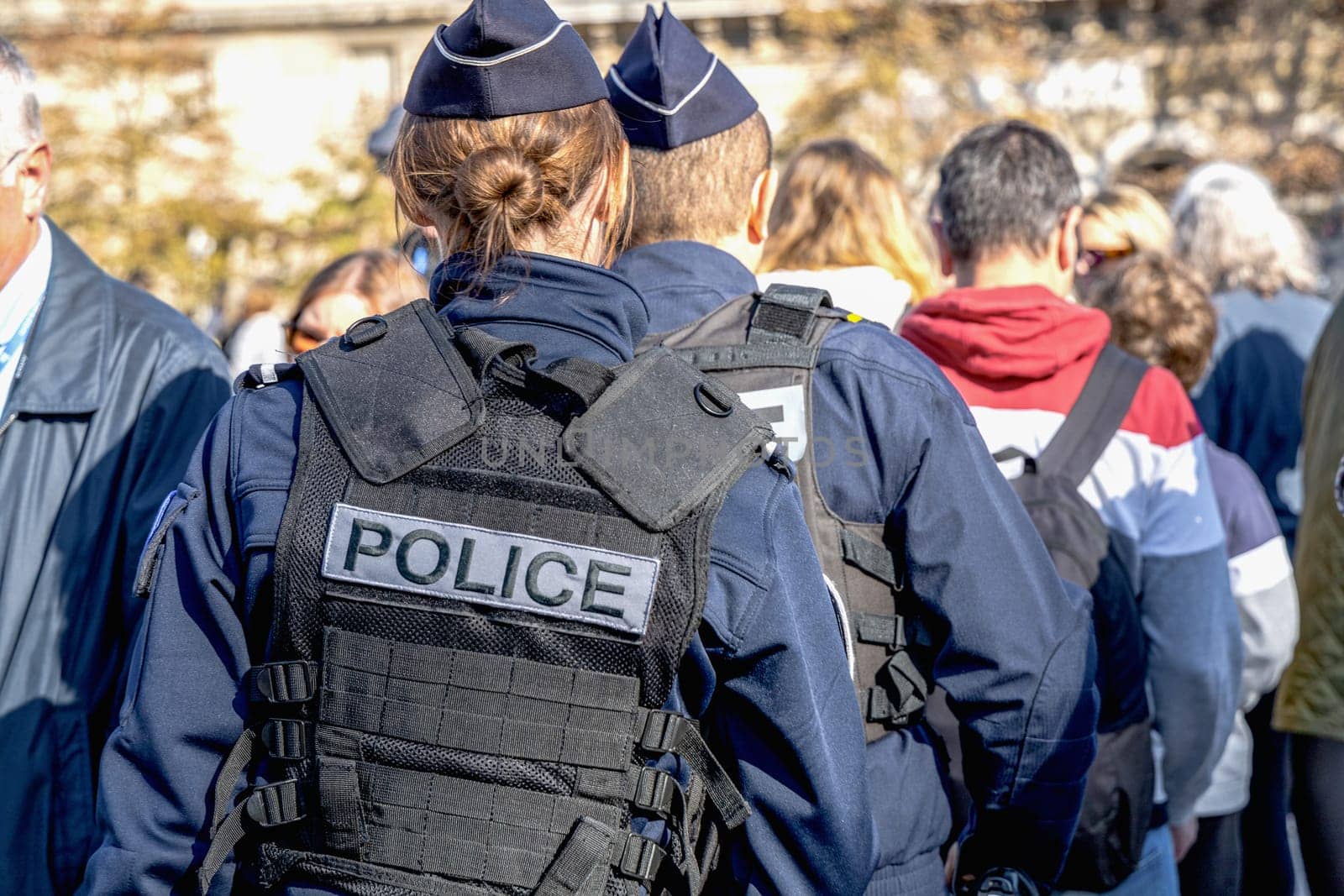 Two policemen, a man and a woman, wearing bulletproof vest with the word police on them. Paris, France - November 1, 2024