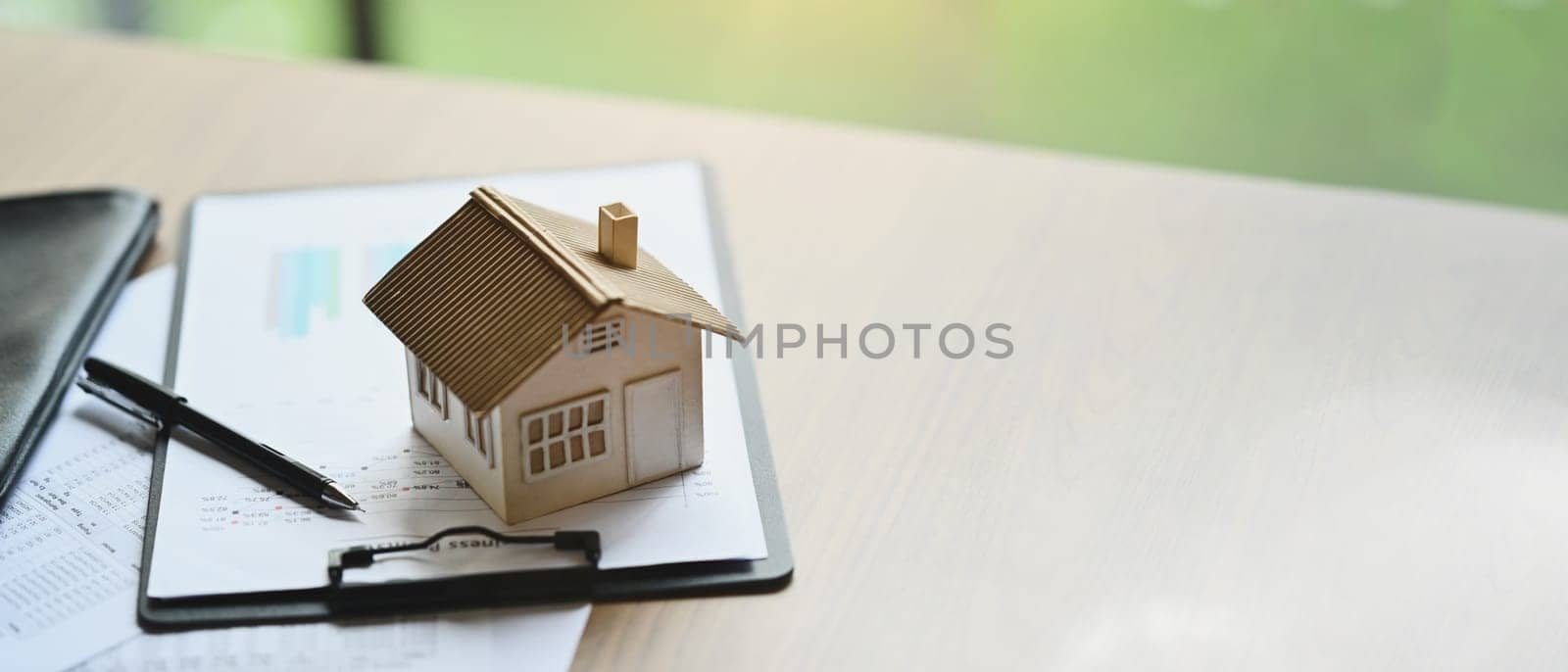 House model and documents on wooden table. Real estate, loan, mortgage and insurance concept.