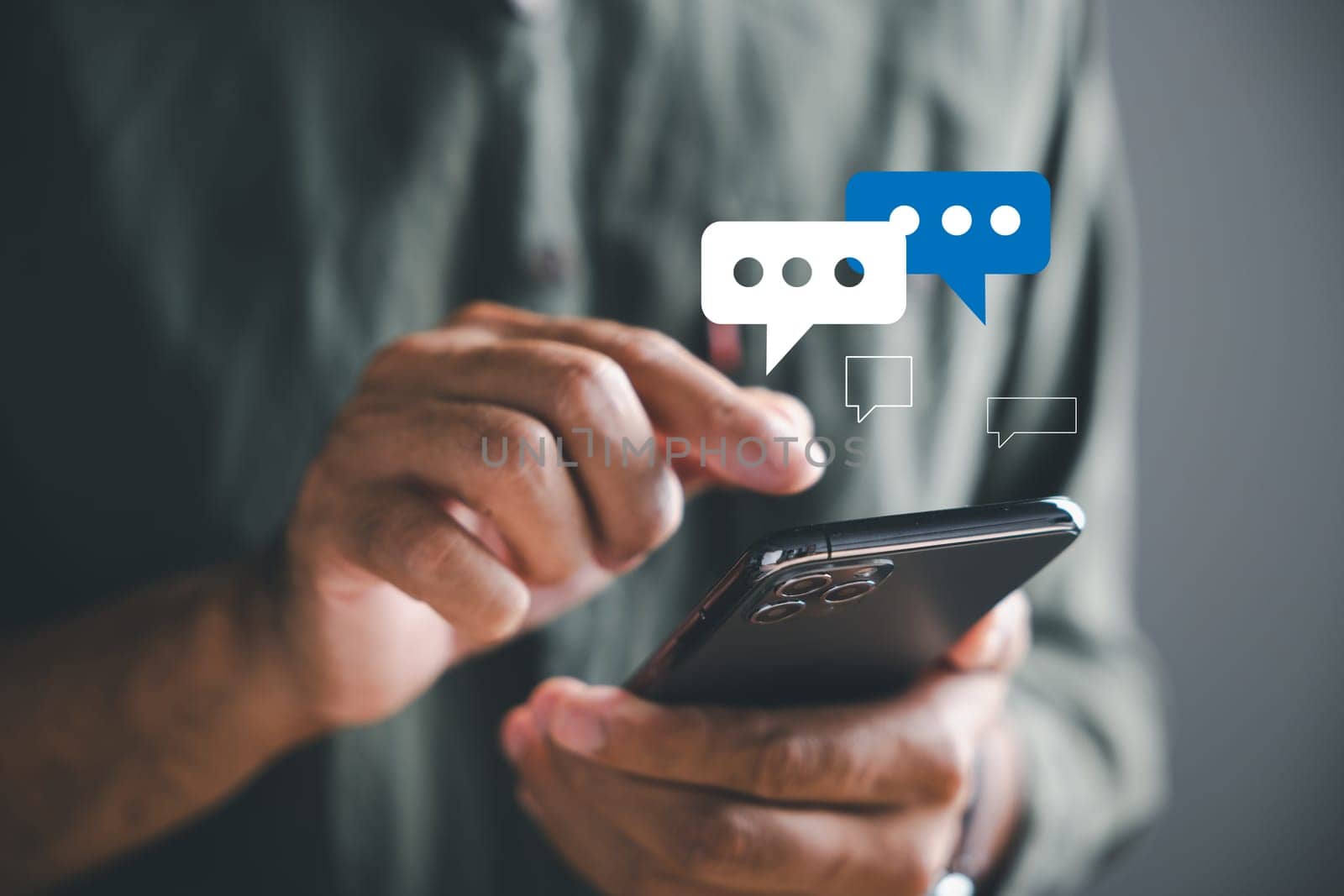 With precision, man hand utilizes his smartphone for live chat engagement, embodying social network and chatting concepts. Chat box icons symbolize technology-driven erof social medimarketing.