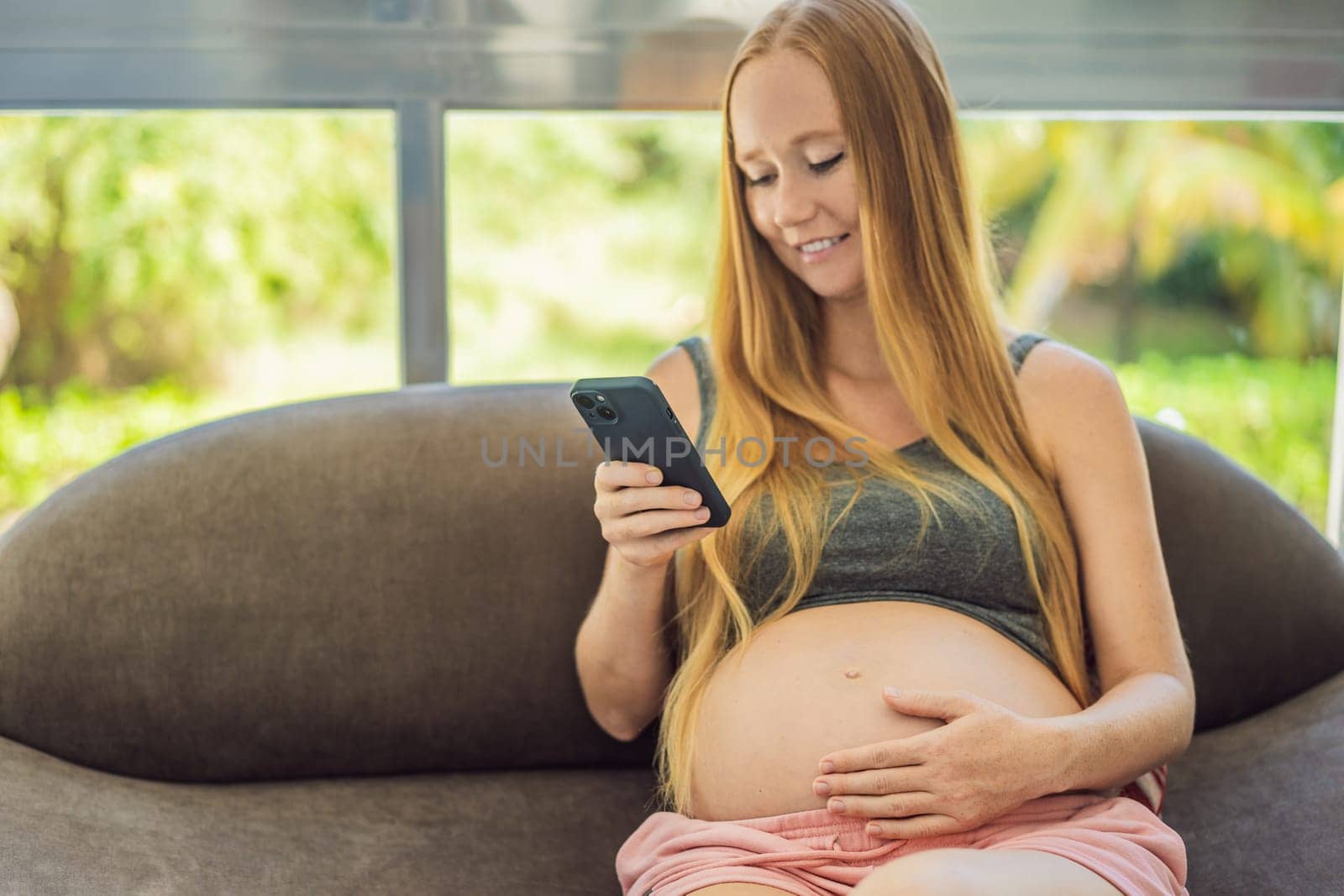 Mobile pregnancy online maternity application. Pregnant mother using phone. Pregnancy, medicine, pharmaceutics, health care and people concept by galitskaya