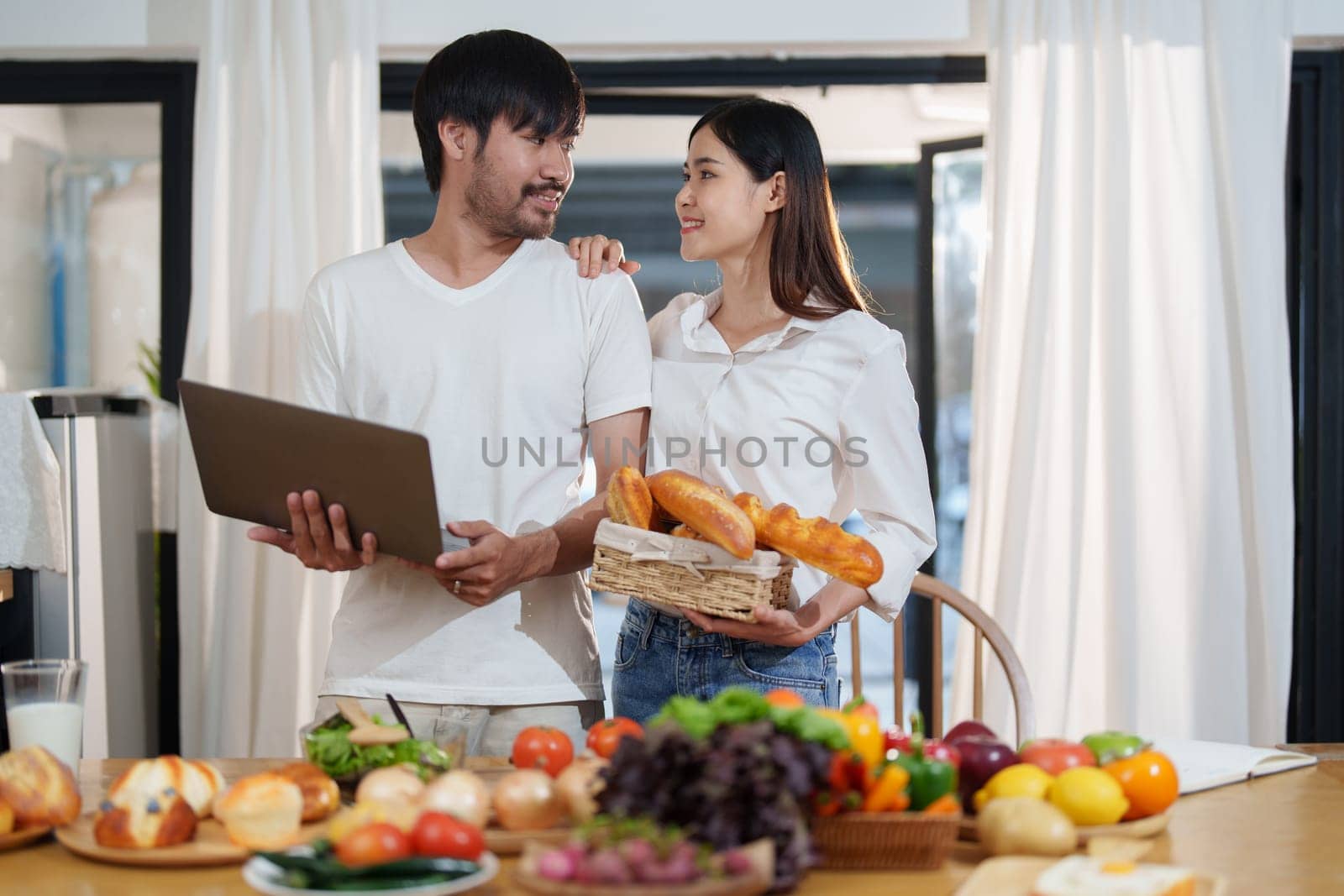 Couple making food or salad in the kitchen at home. by Manastrong