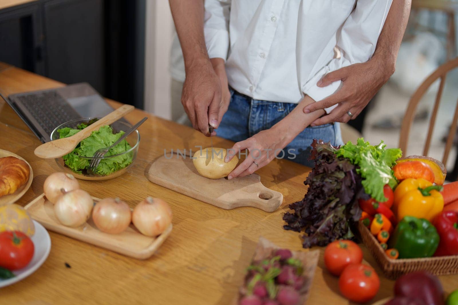 Couple cutting potatoes to cook or make salad in home kitchen