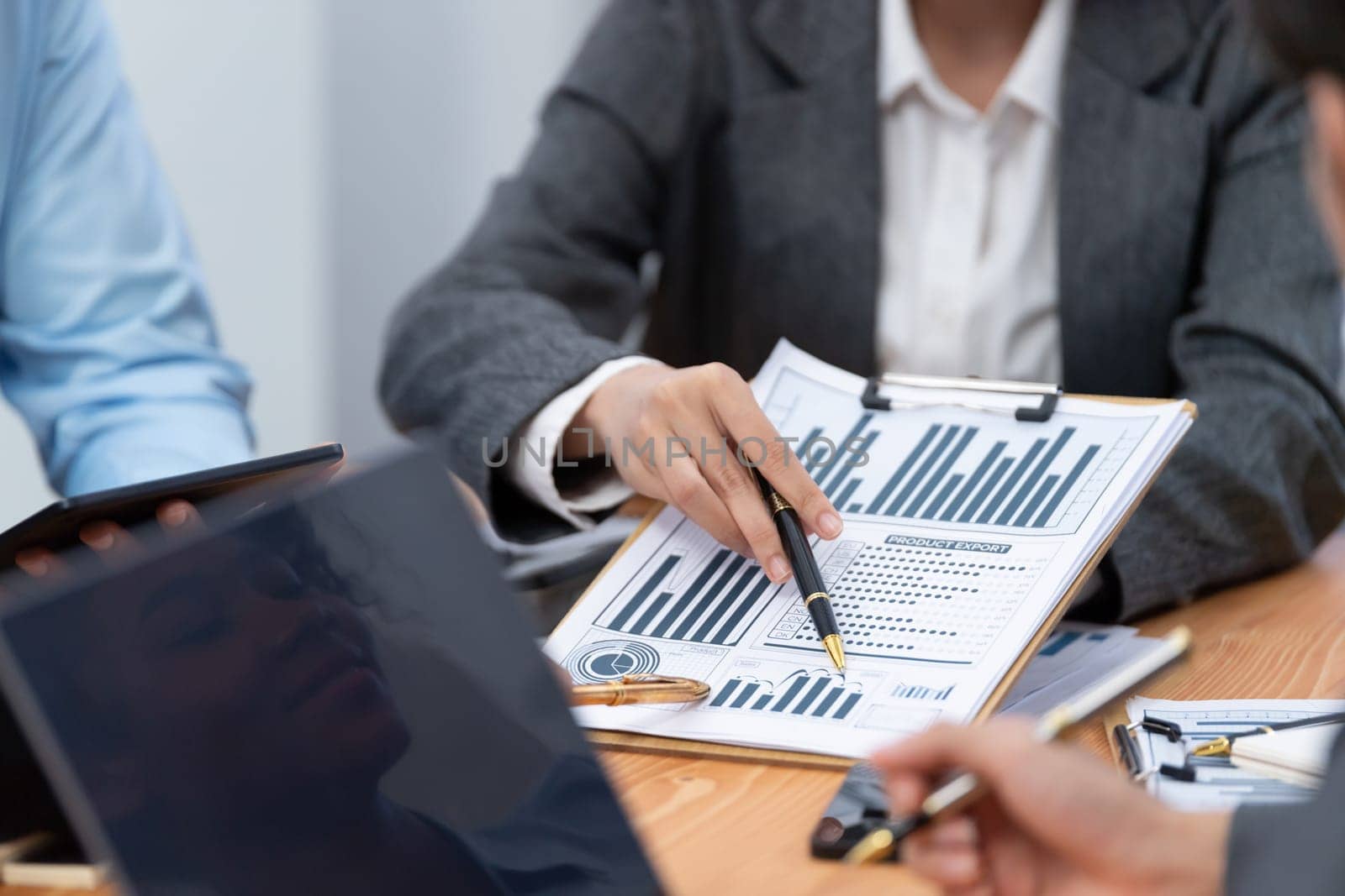 Multiracial analyst team use BI dashboard data to analyze financial report on meeting table. Group of diverse business people utilize data analysis by FIntech for business marketing decision. Concord