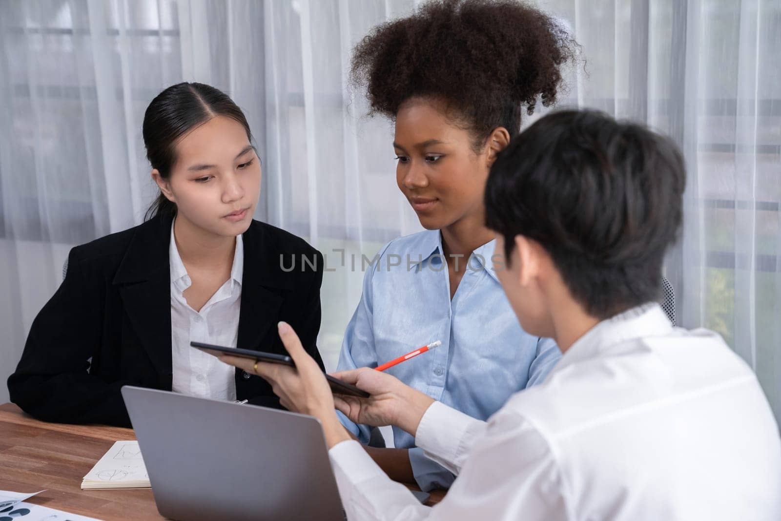 Happy diverse business people work together, discussing in corporate office. Professional and diversity teamwork discuss business plan on desk with laptop. Modern multicultural office worker. Concord