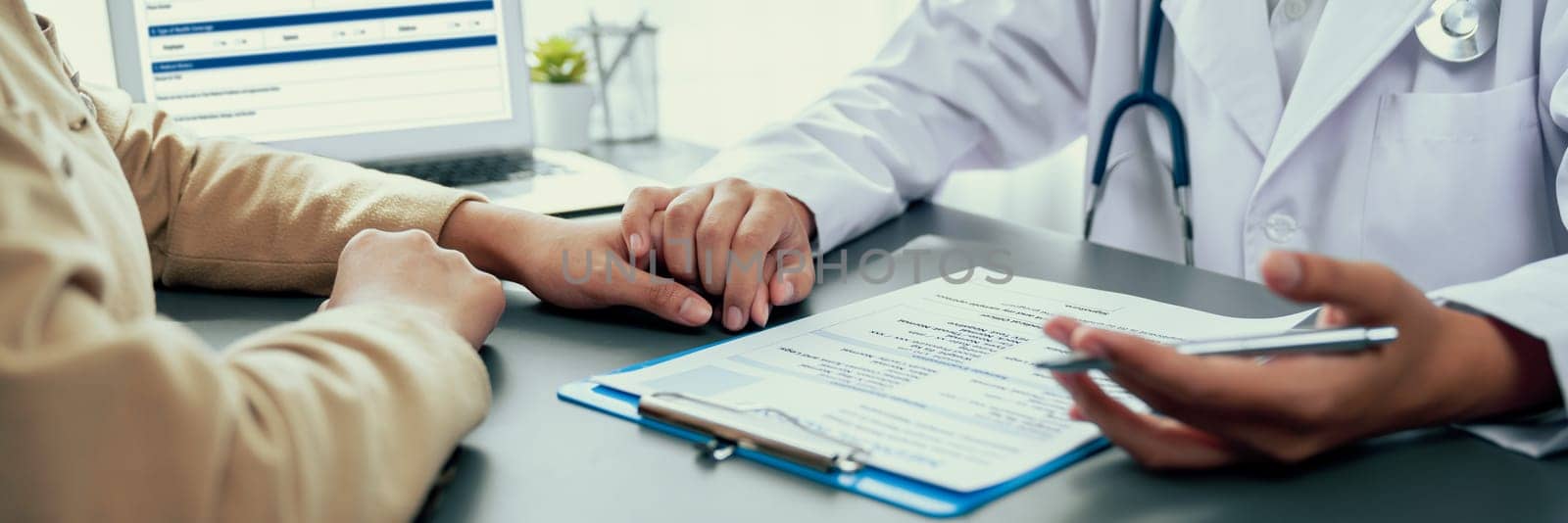 Doctor show medical diagnosis report and providing compassionate healthcare consultation while holding young patient hand for being supportive and professional in doctor clinic office. Neoteric