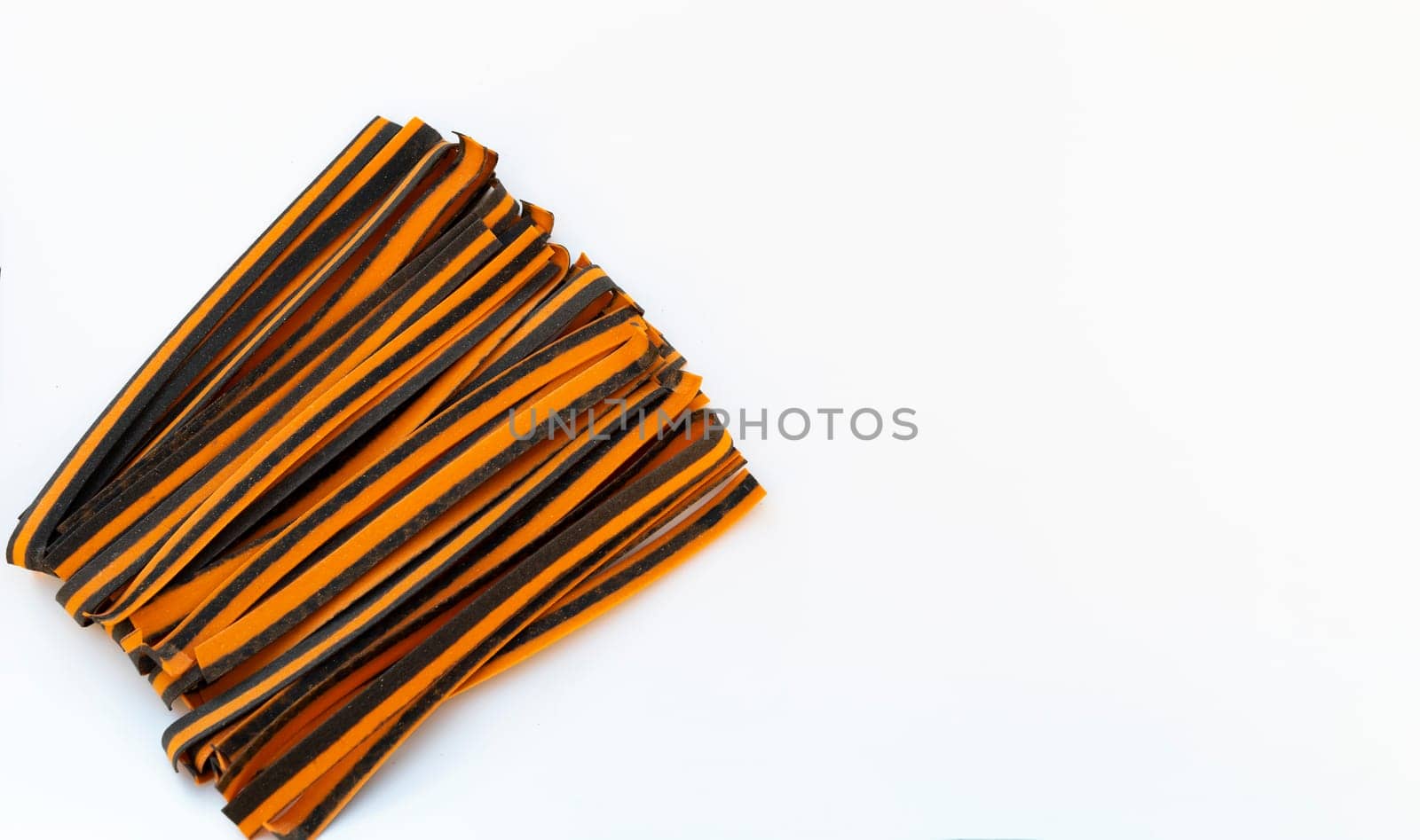 Black And Orange Pappardelle Italian Pasta, Fresh Wheat Product on White Background. Top View, Space For Text. Egg Dry Ribbon Noodles, Long Rolled Macaroni or Uncooked Spaghetti Isolated. Horizontal.