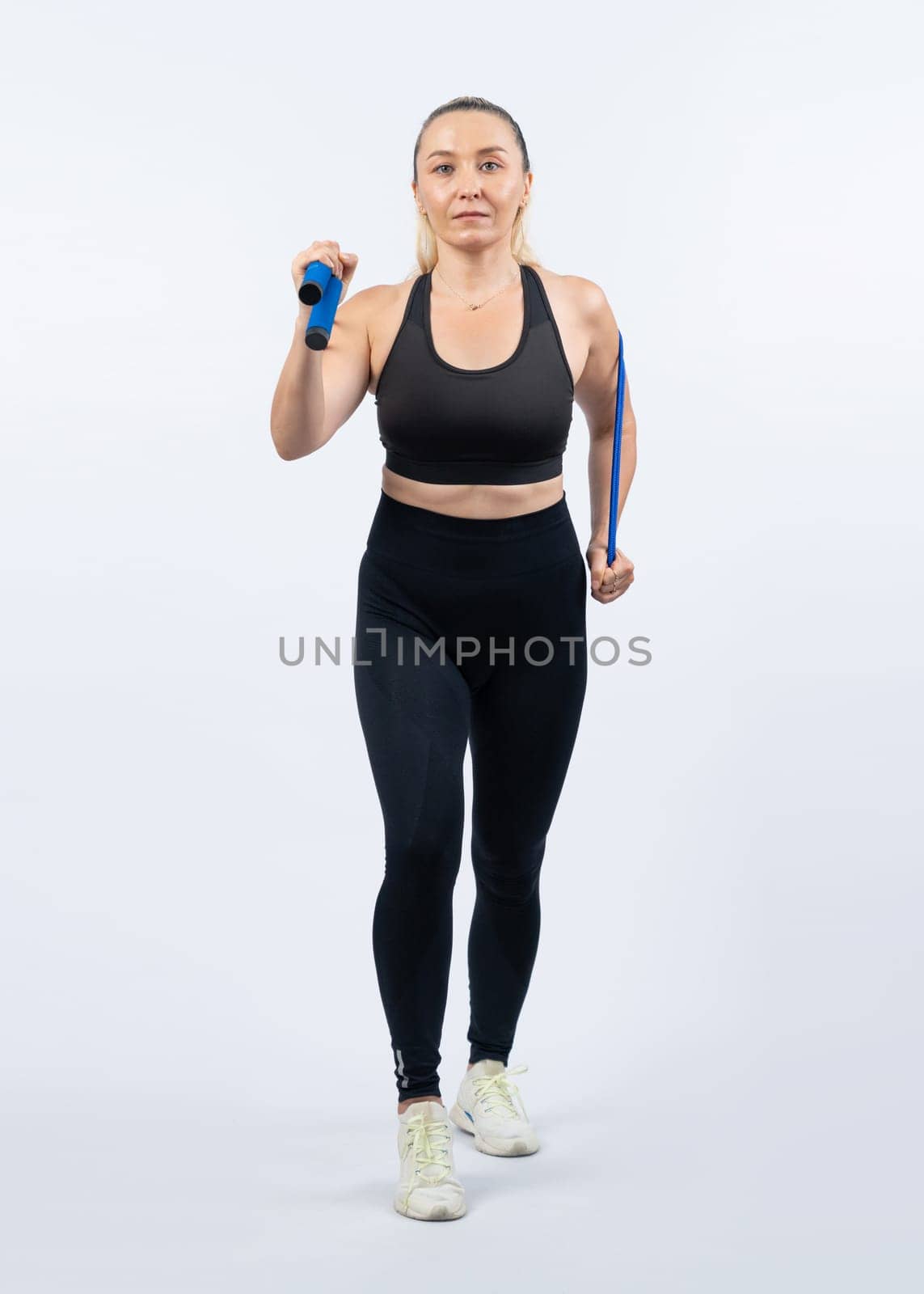 Full body length shot athletic and sporty senior woman with fitness exercising rope on isolated background. Healthy active physique and body care lifestyle senior people. Clout