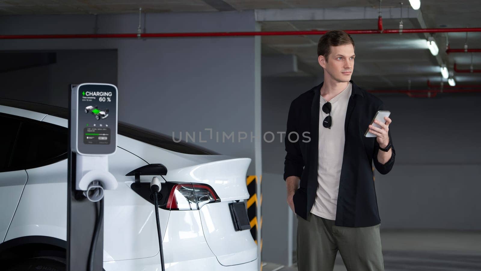 Young man travel with EV electric car to shopping center parking lot innards by biancoblue