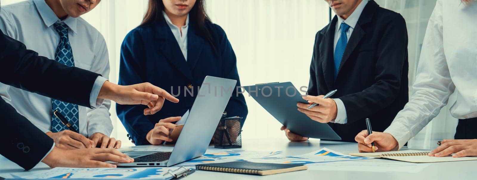 Business people in group meeting in formal attire share idea discussing report for company profit in creative workspace for start up business shot in close up view on group meeting table . Oratory .