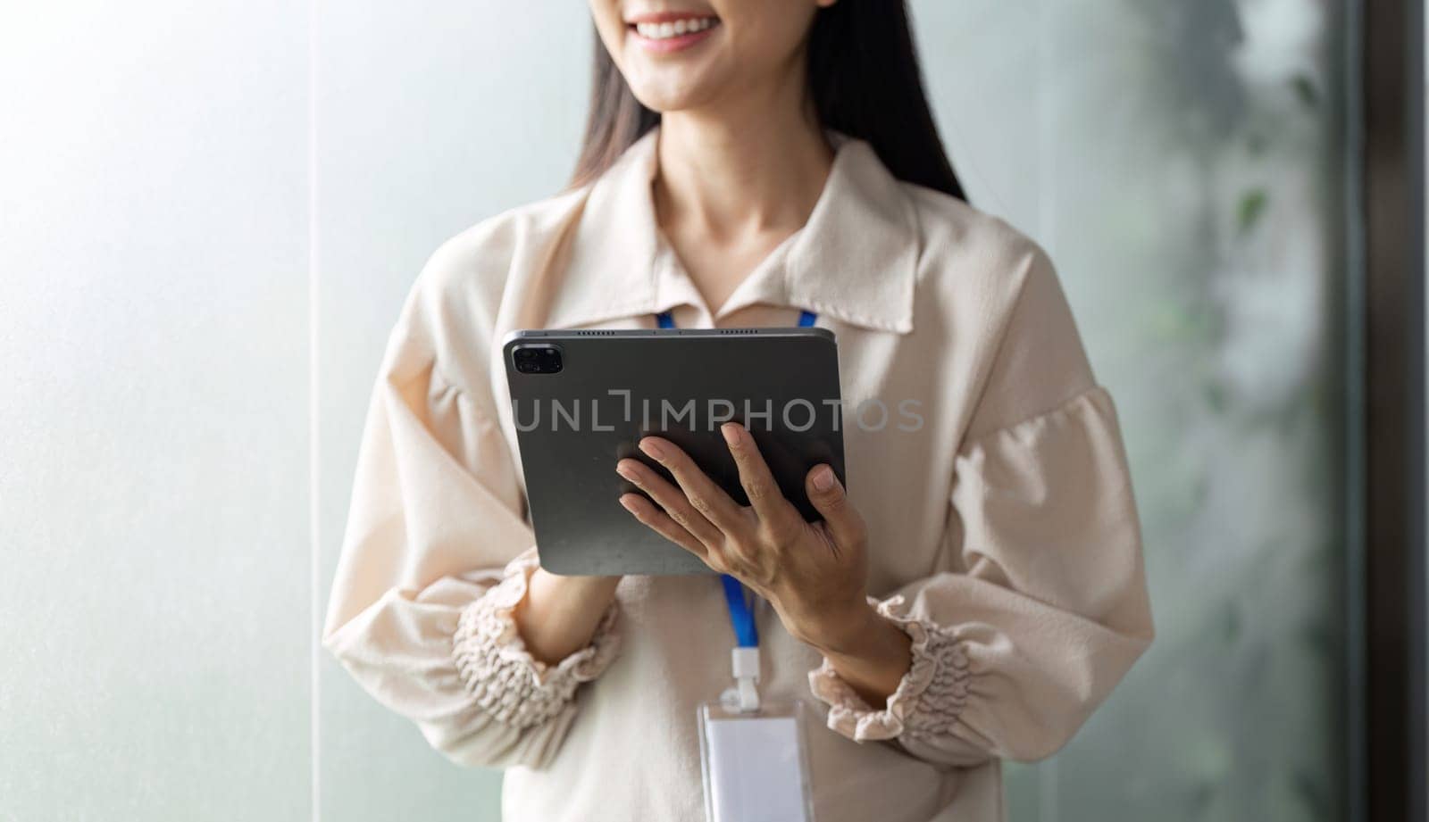 A focused businesswoman uses a tablet in a contemporary office enhancing productivity and collaboration.
