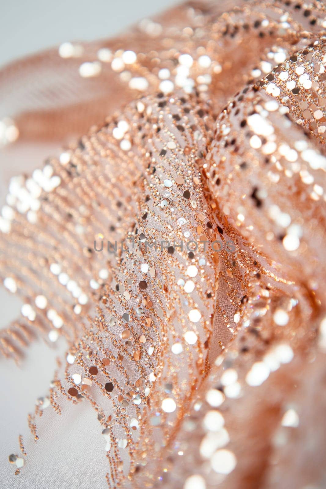 Close up of shimmering rose gold sequin fabric, showcasing texture and sparkle, perfect for fashion, crafts, or design projects