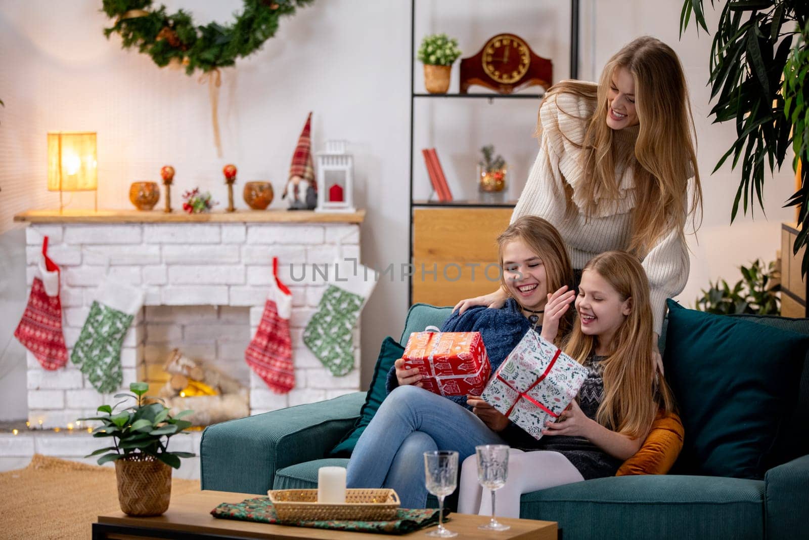 A warm festive scene beautifully capturing friends joyfully opening presents by the cozy fireplace during the holidays